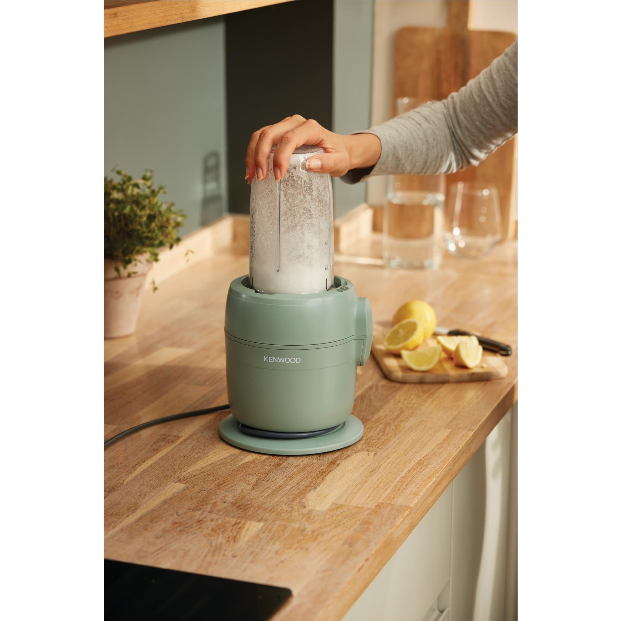 Kenwood MultiPro Go food processor on eucalyptus base with hands pouring into jug