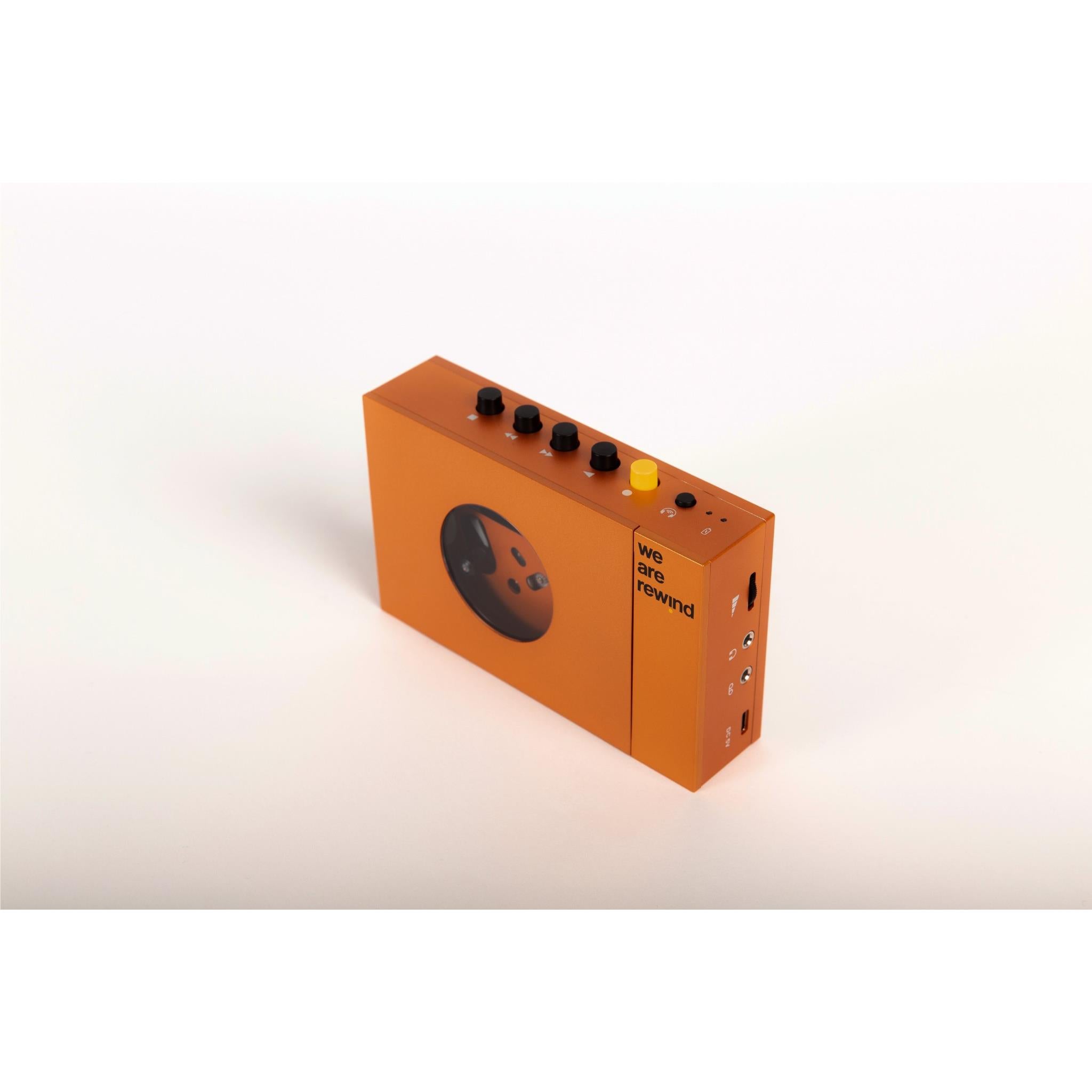 Orange cassette tape player side view with top controls and port openings