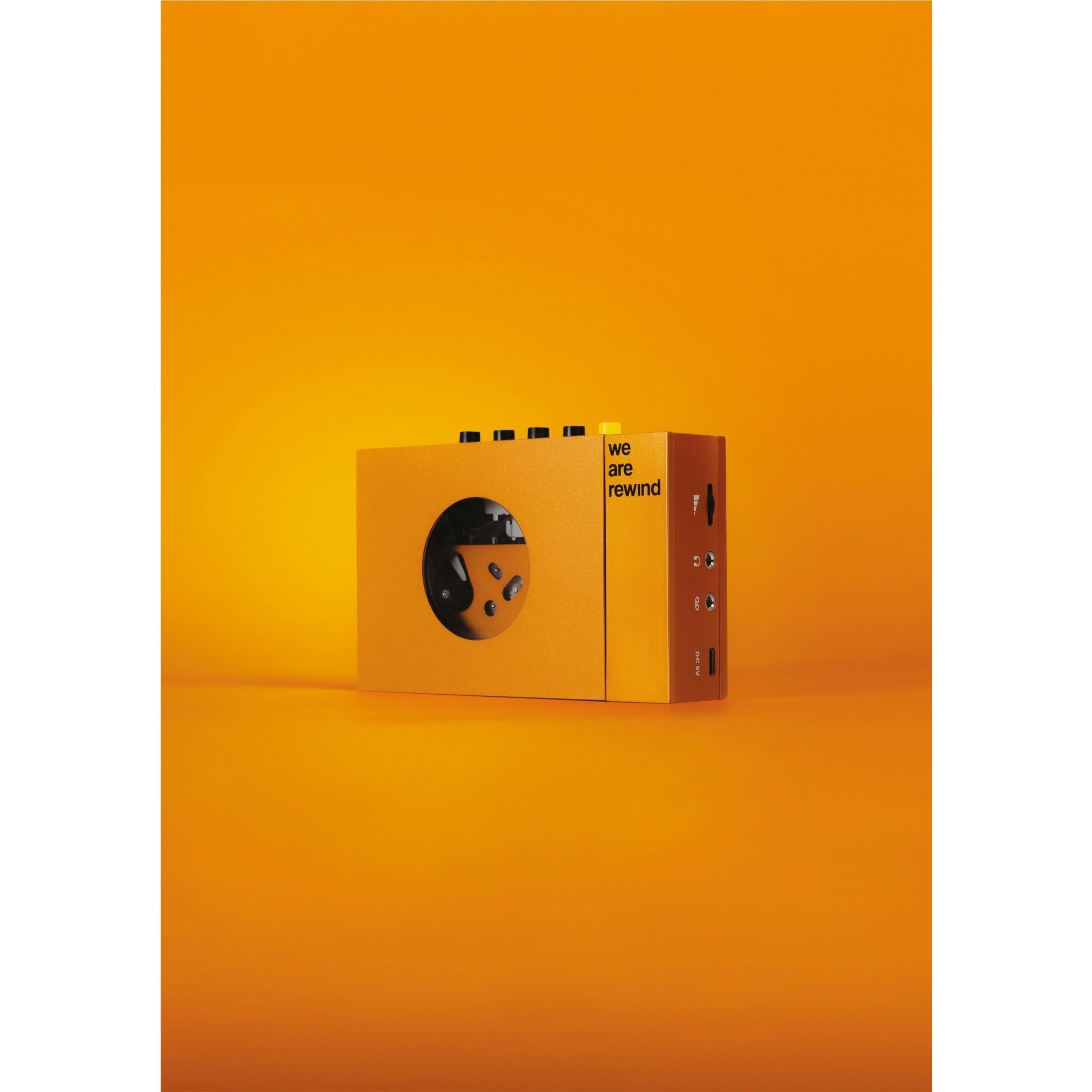 Orange cassette tape player with front circular window and "we are rewind" logo