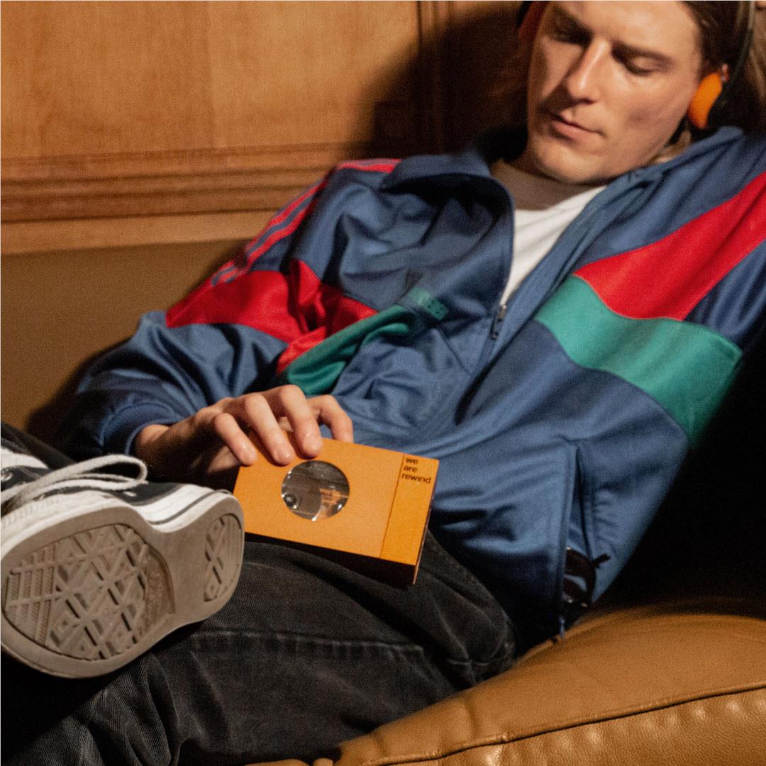 Orange cassette tape player held on lap, front circular window visible