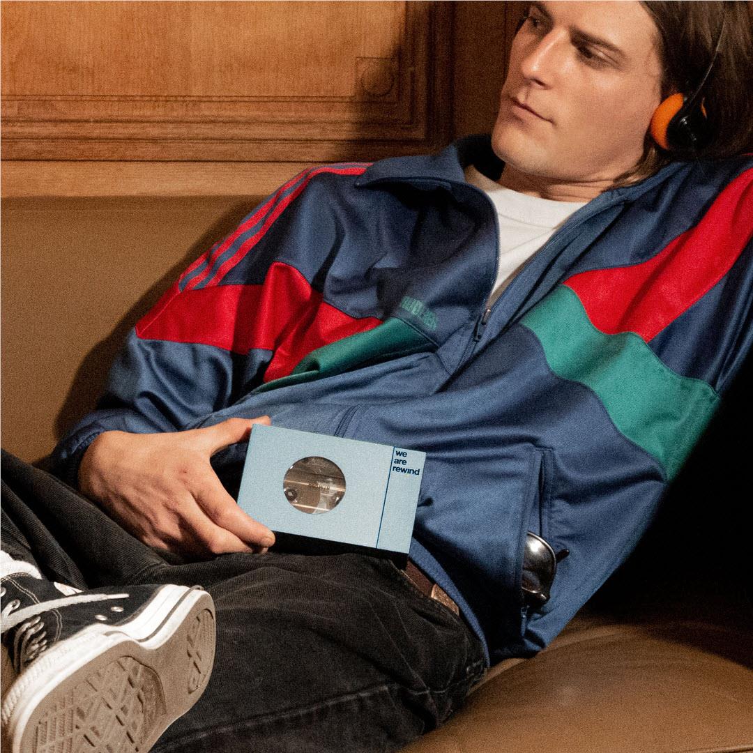 Person holding a blue rechargeable Bluetooth cassette player with circular window