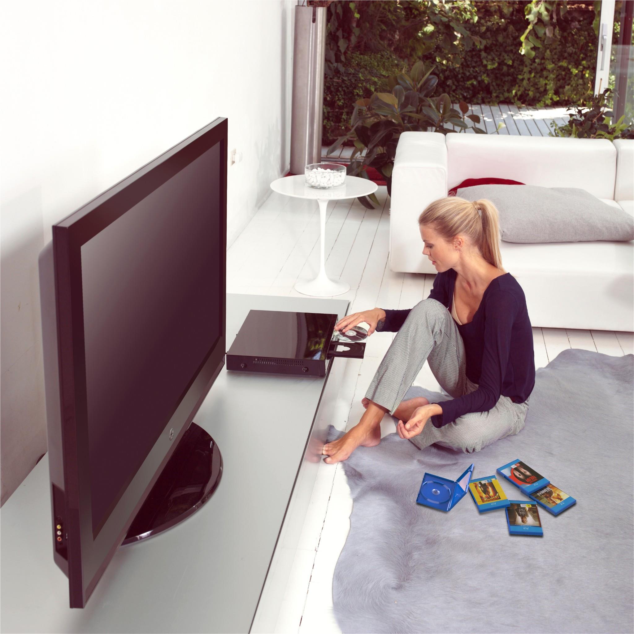 Blu-ray player on side table with person and disc cases nearby