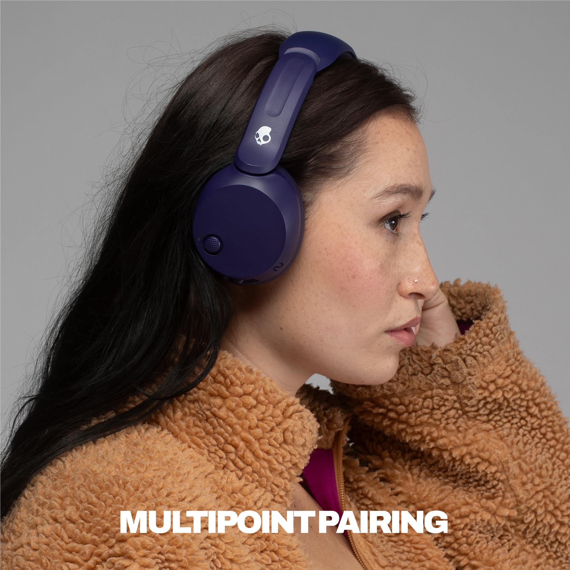 Wireless over-ear headphones worn with dark hair, cushioned dark purple ear cups