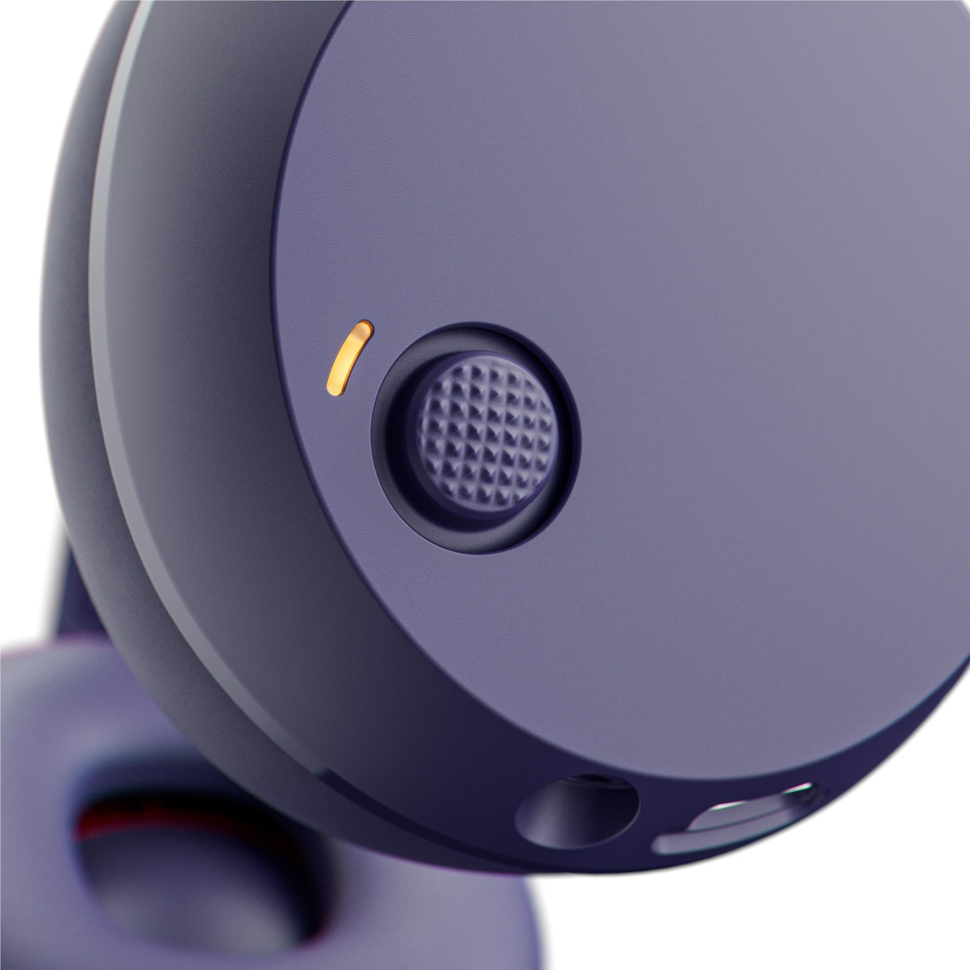 Close-up of dark purple ear cup with speaker grille and small LED indicator light