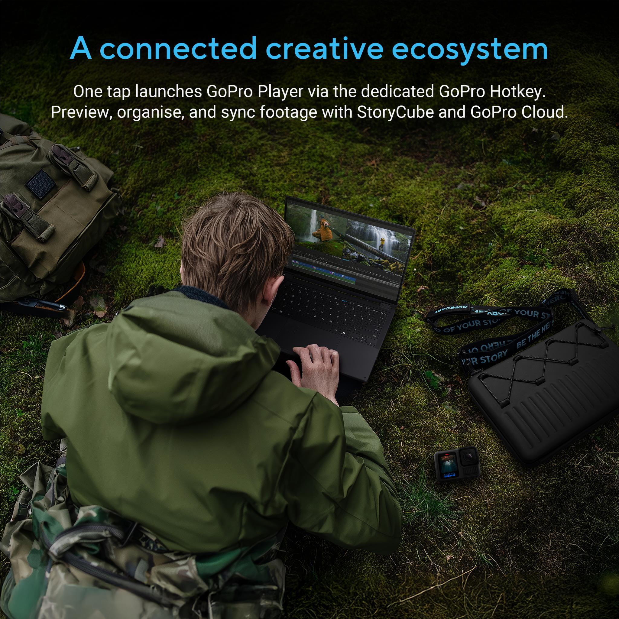 ASUS ProArt laptop on grass with camera bags and GoPro case around