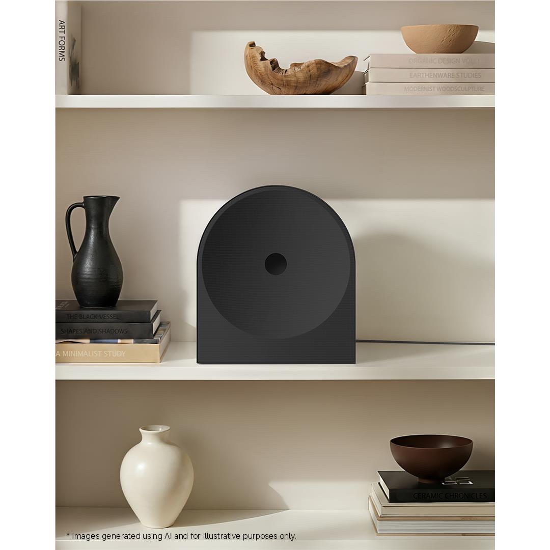 Black speaker sitting on a shelf with centered circular driver
