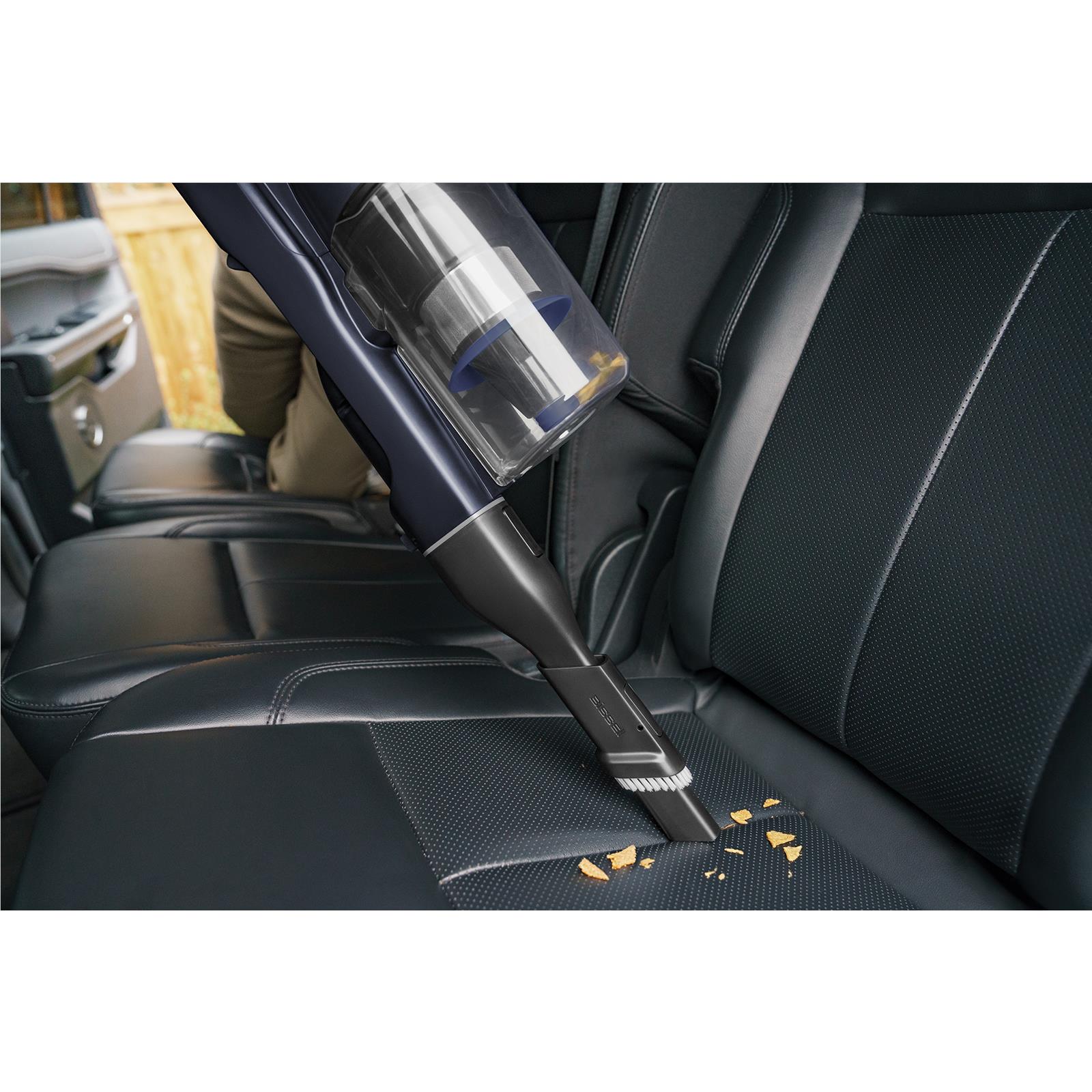 Bissell PowerClean vacuum nozzle cleaning crumbs from upholstered sofa seat
