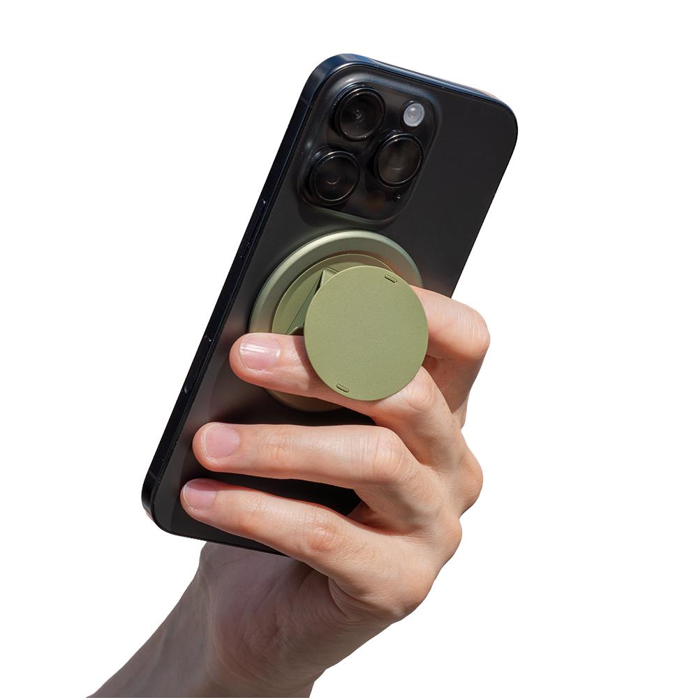 Green circular magnetic phone grip attached to a smartphone, hand holding