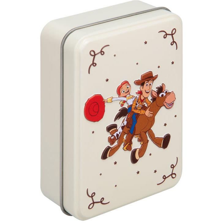 Matching metal tin with cowboy character illustration and card-suit symbol corners