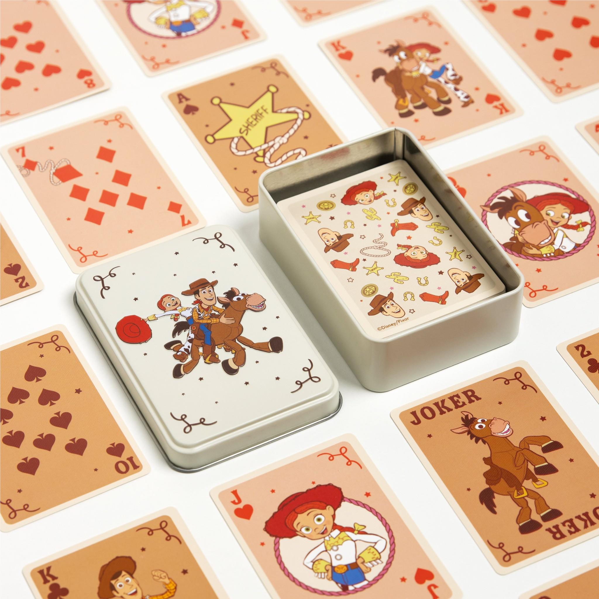 Two metal tins and spread playing cards with cowboy and character illustrations