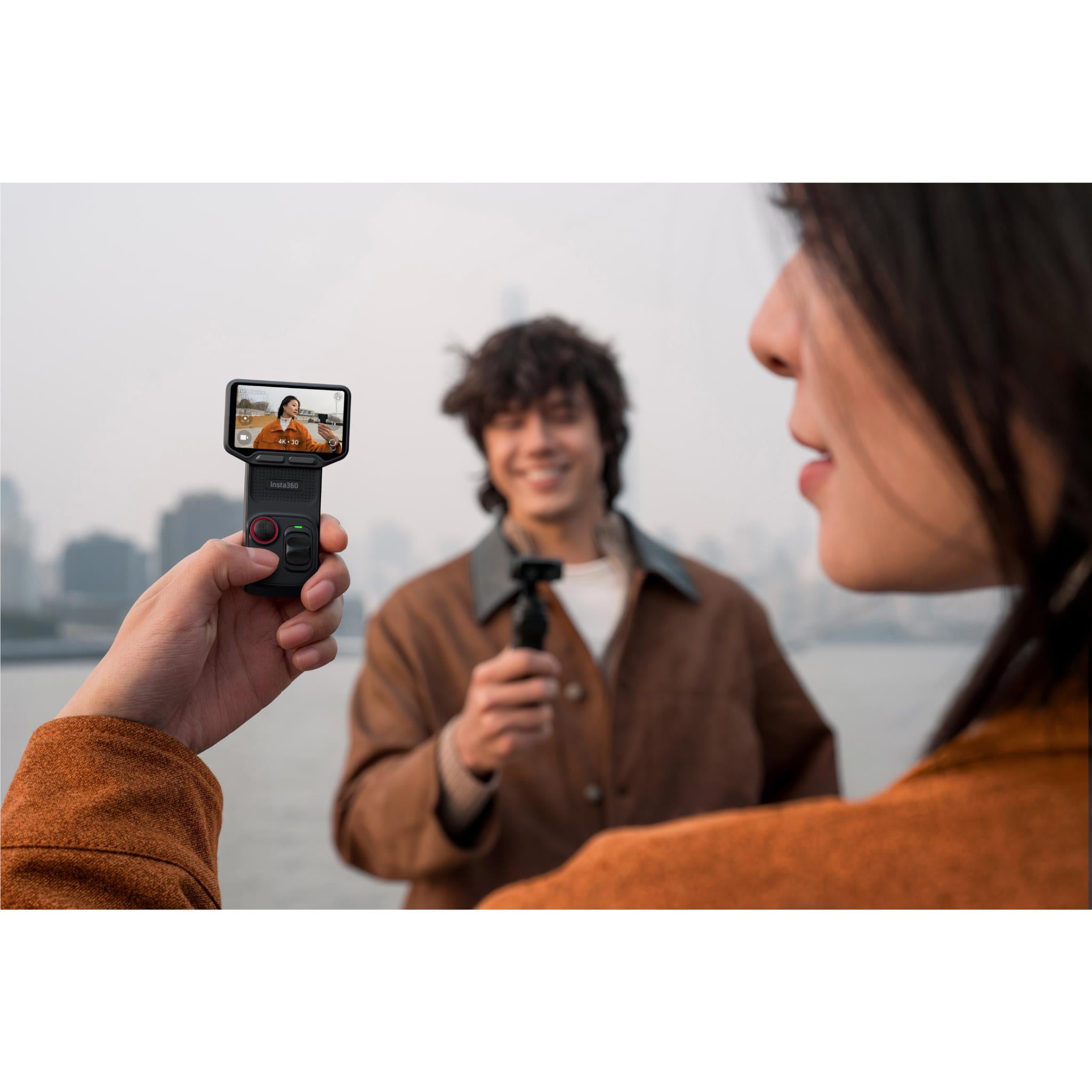 Black gimbal camera in hand with small screen preview for recording