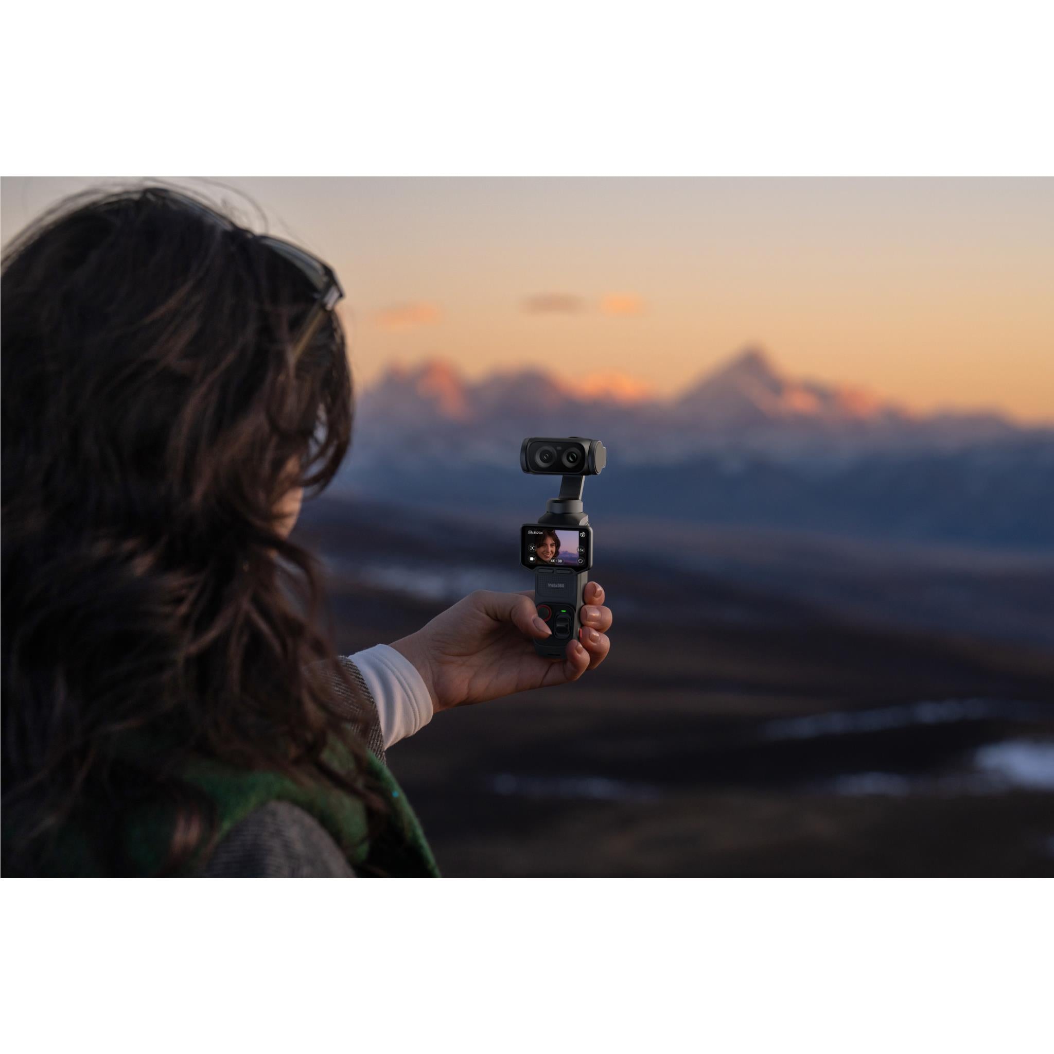 Black gimbal camera held up toward the sky with front display showing