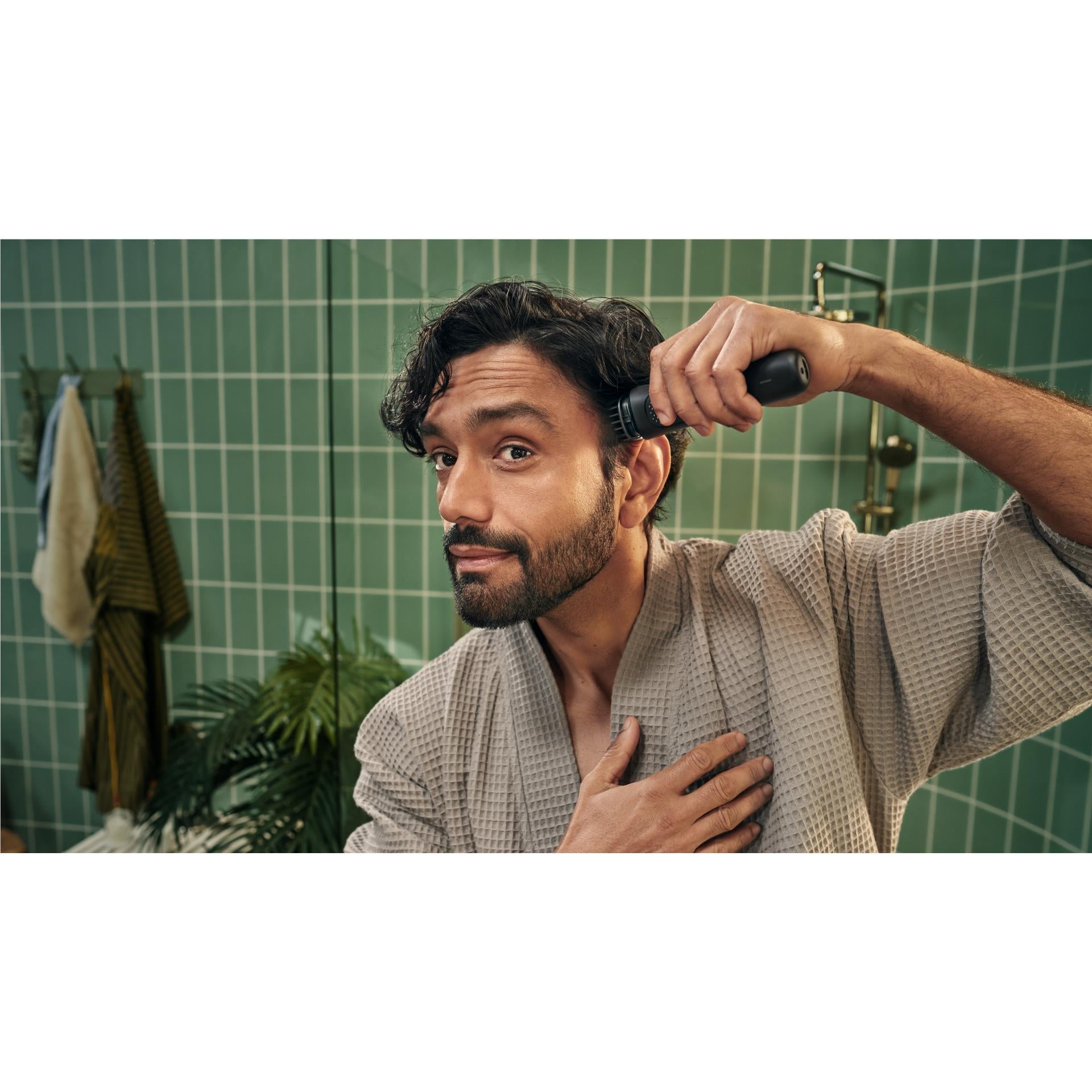 Handheld black face trimmer with guard used to trim a man's beard