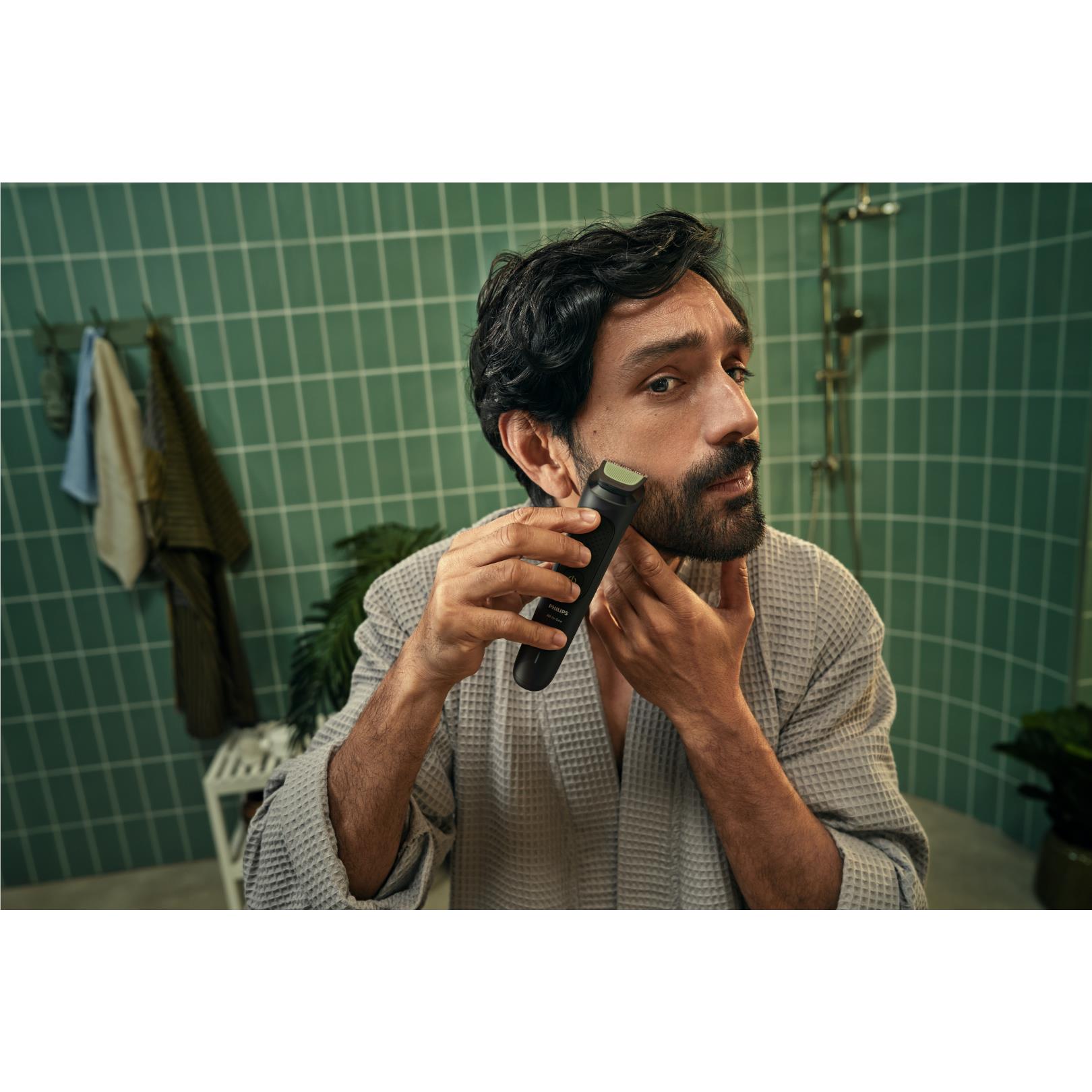 Handheld black face trimmer trimming a man's beard along the cheek and jaw