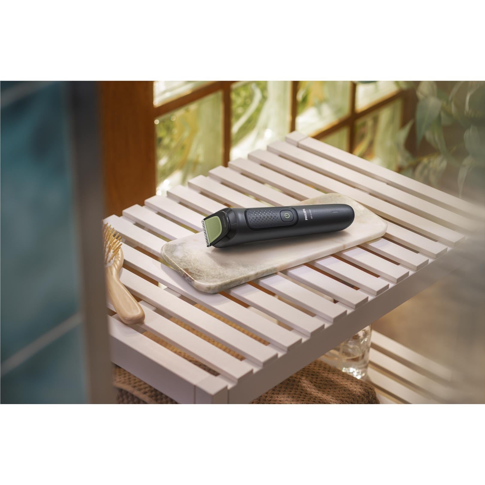 Black trimmer resting on grooming stand with guide combs
