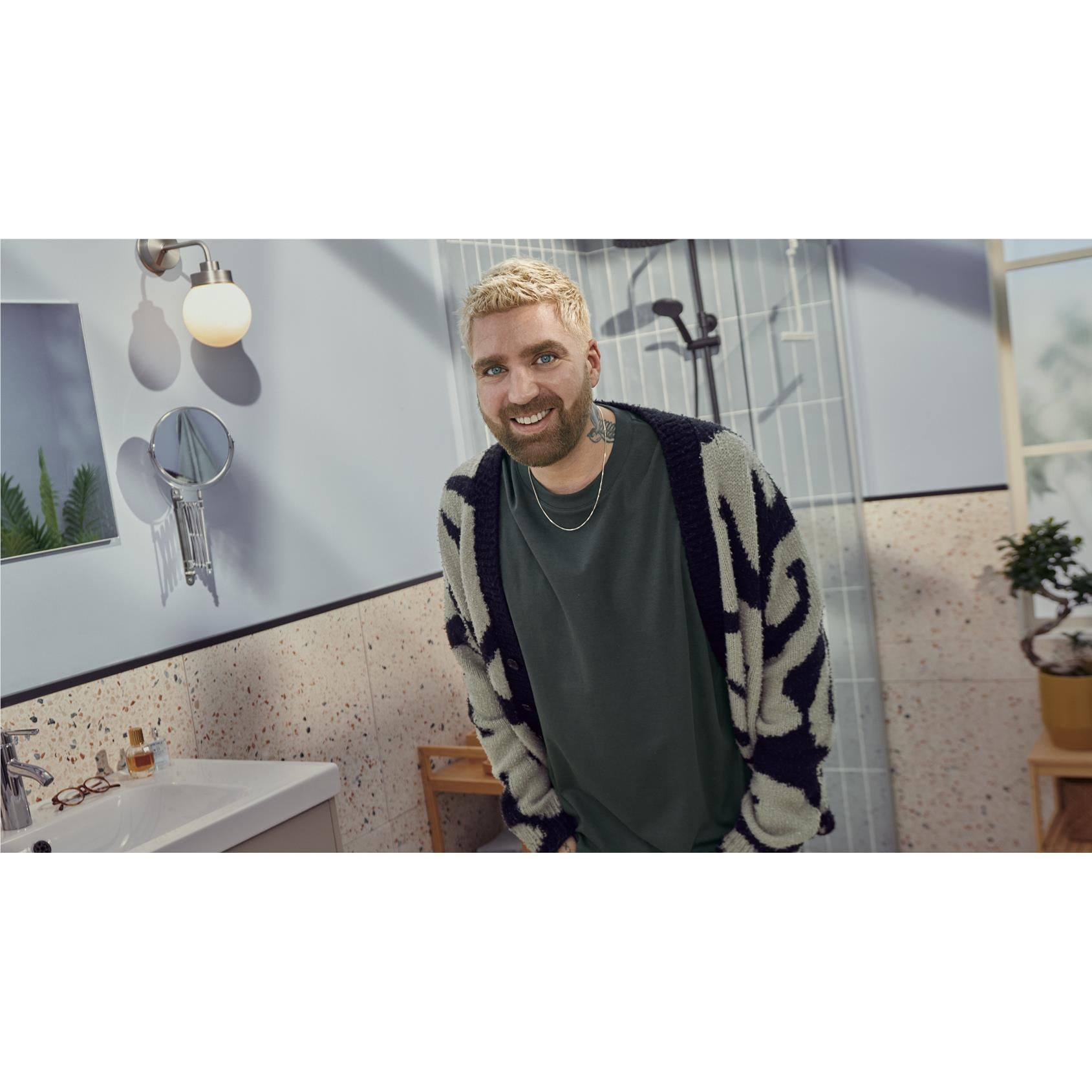 Beard grooming: man holding a Philips beard trimmer to his beard