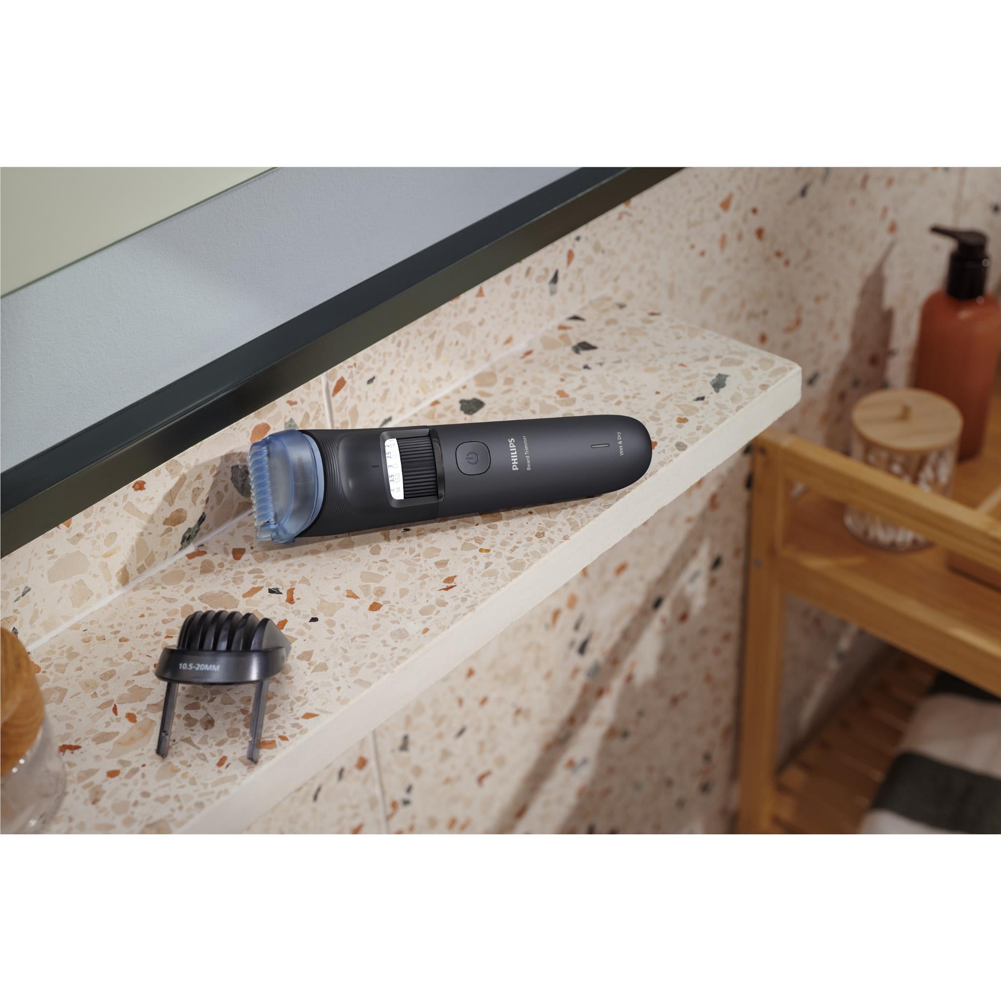 Philips beard trimmer on bathroom sink counter with blue guard attachment