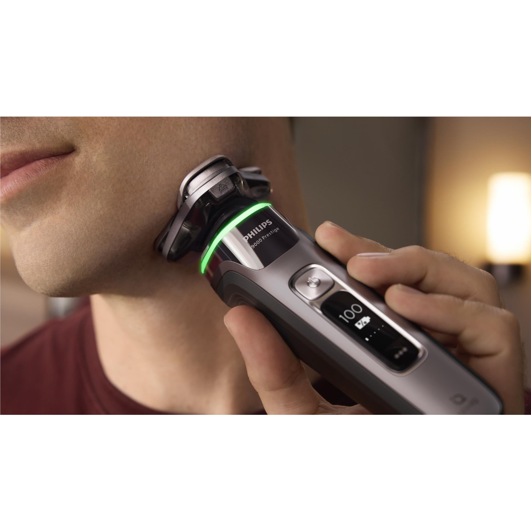 Electric shaver in use along jawline with green indicator light
