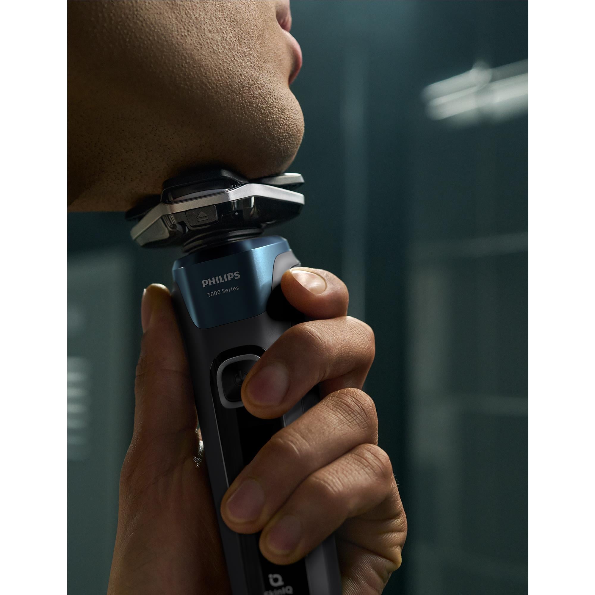 Electric foil shaver pressed along the chin and jaw, held in a hand