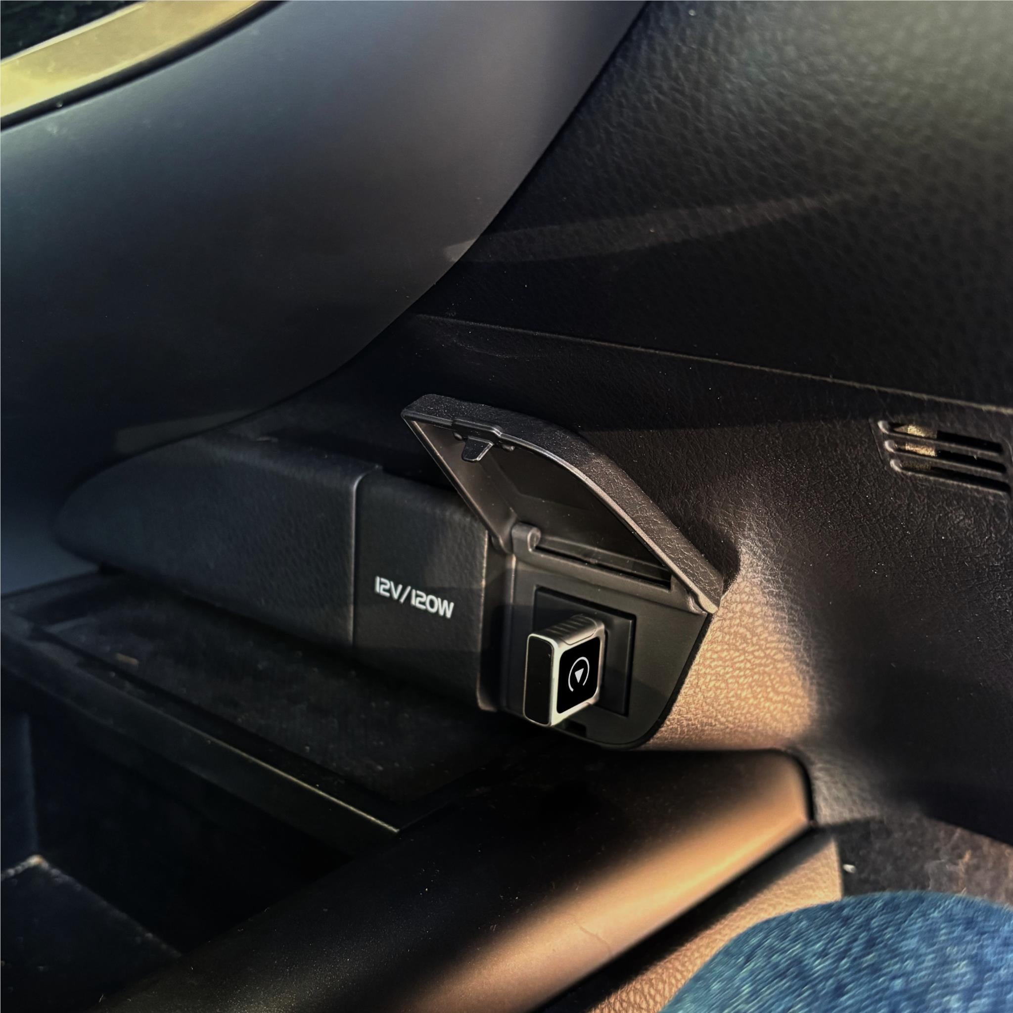Wireless CarPlay mini dongle adapter plugged into car 12V/20V outlet