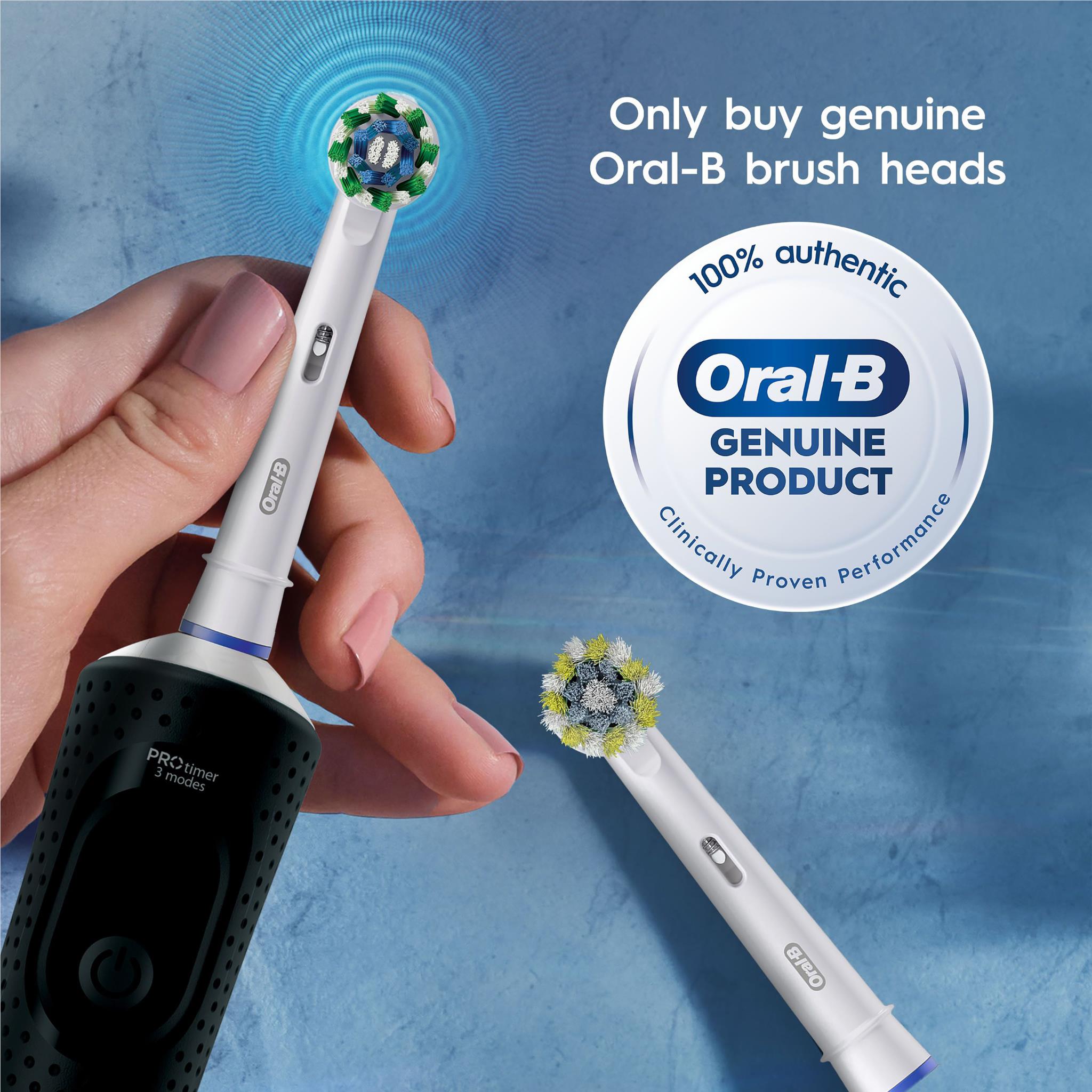 Hand holding an Oral-B replacement brush head with additional brush heads