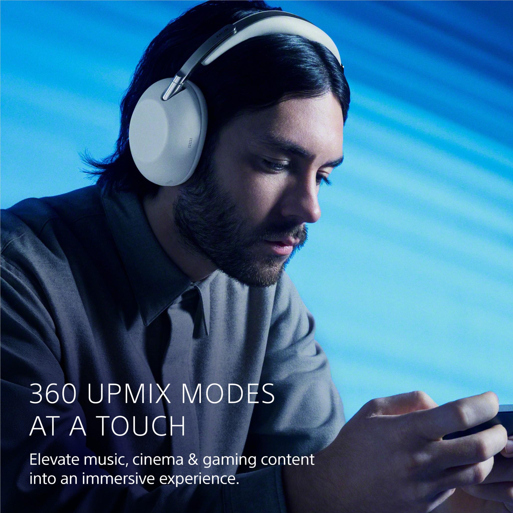 Over-ear noise cancelling headphones with white earcups, close-up worn by man