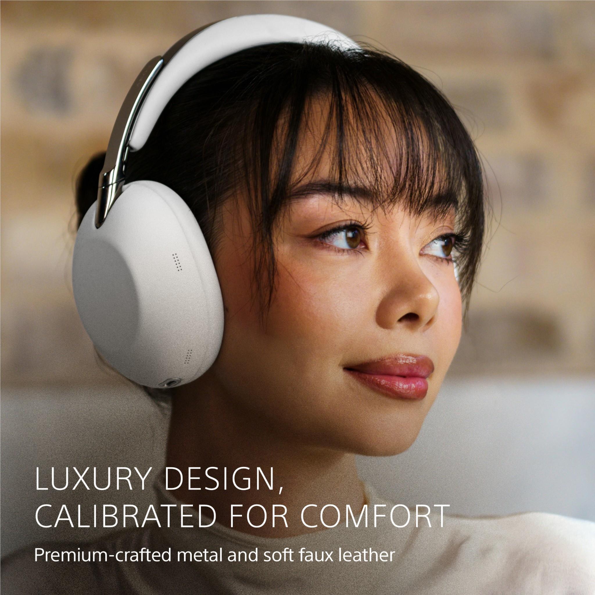 White over-ear headphones with cushioned ear cups worn by a person