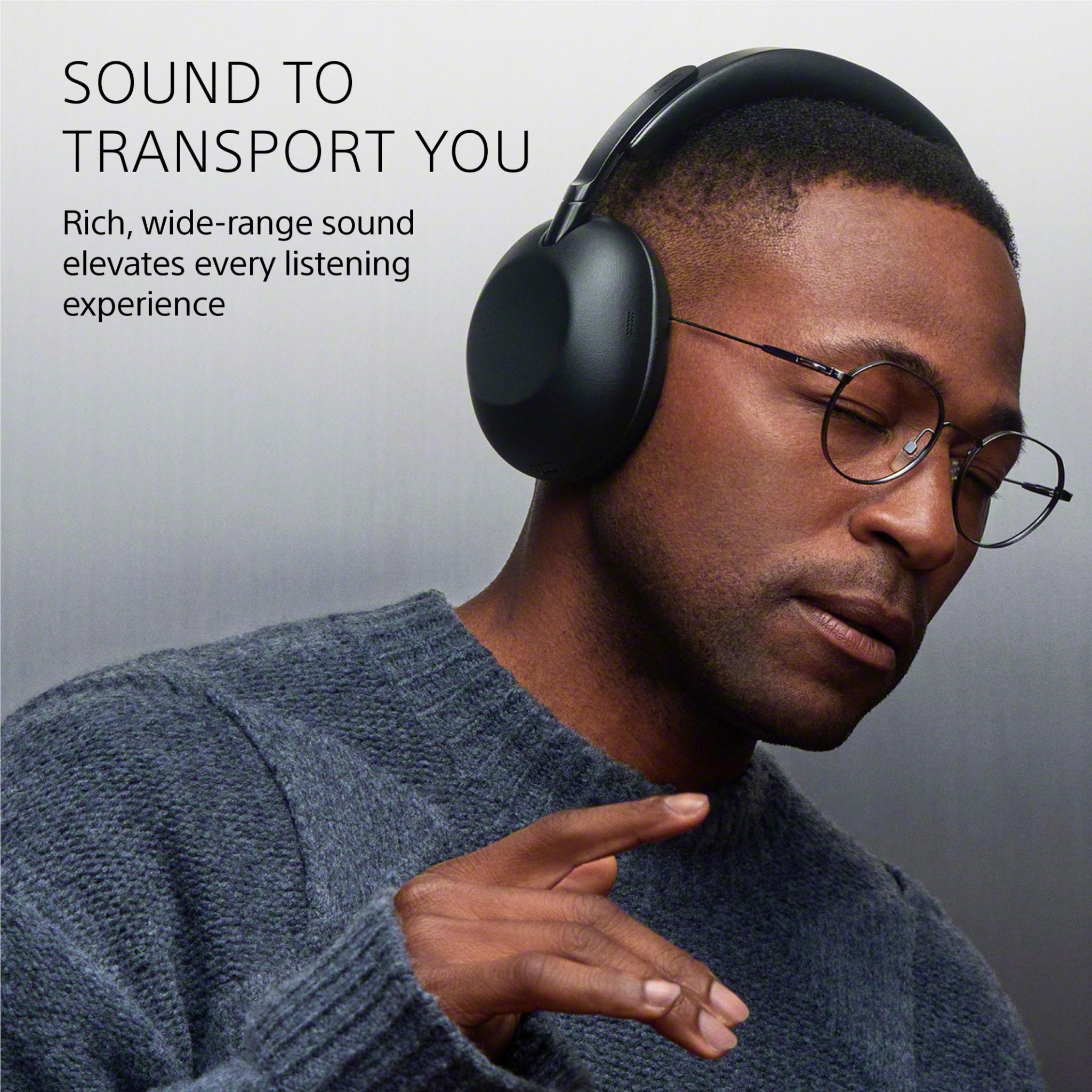 Black over-ear headphones with cushioned ear cups worn by a person