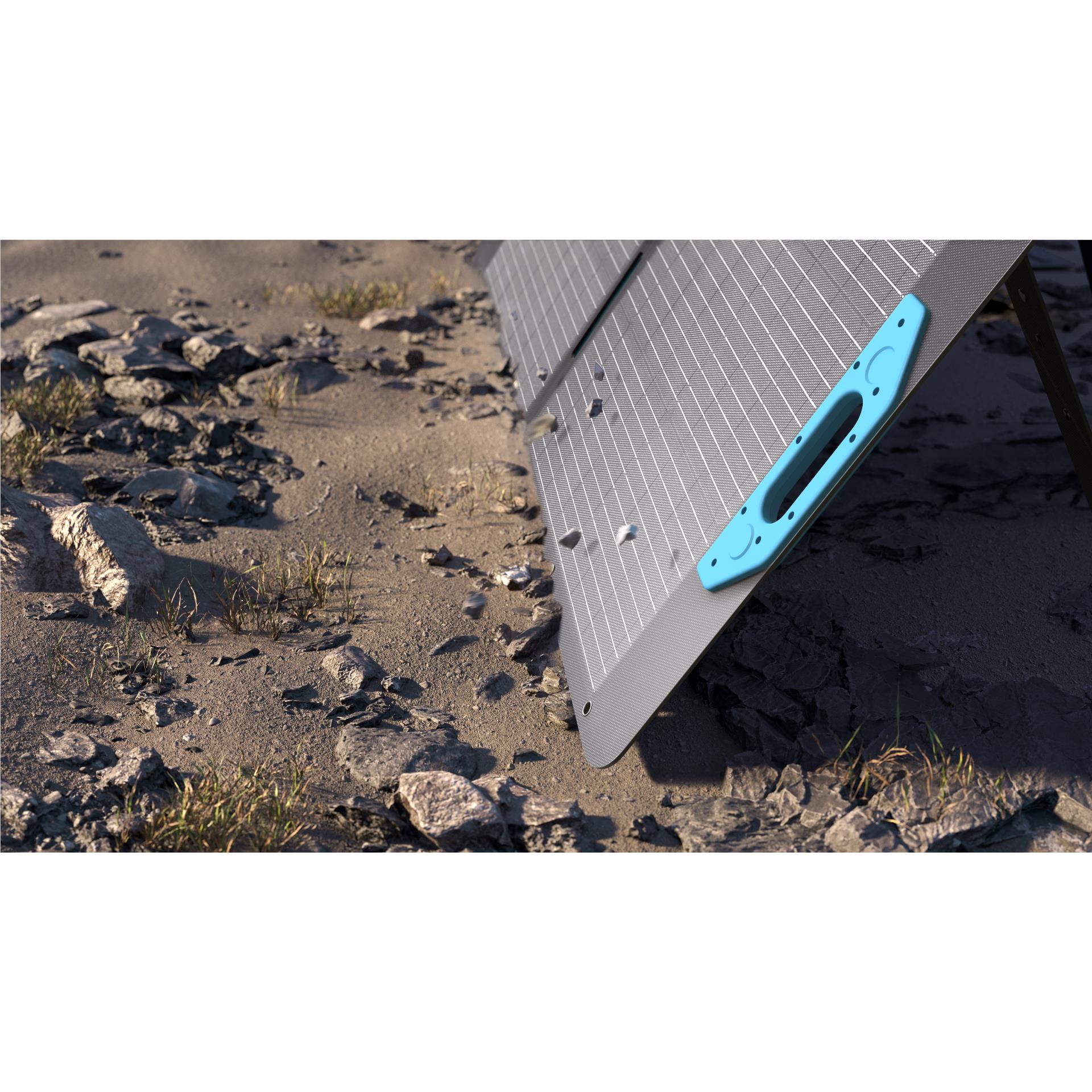 Foldable bifacial solar panel on rocky ground, dark grid cells and blue handles