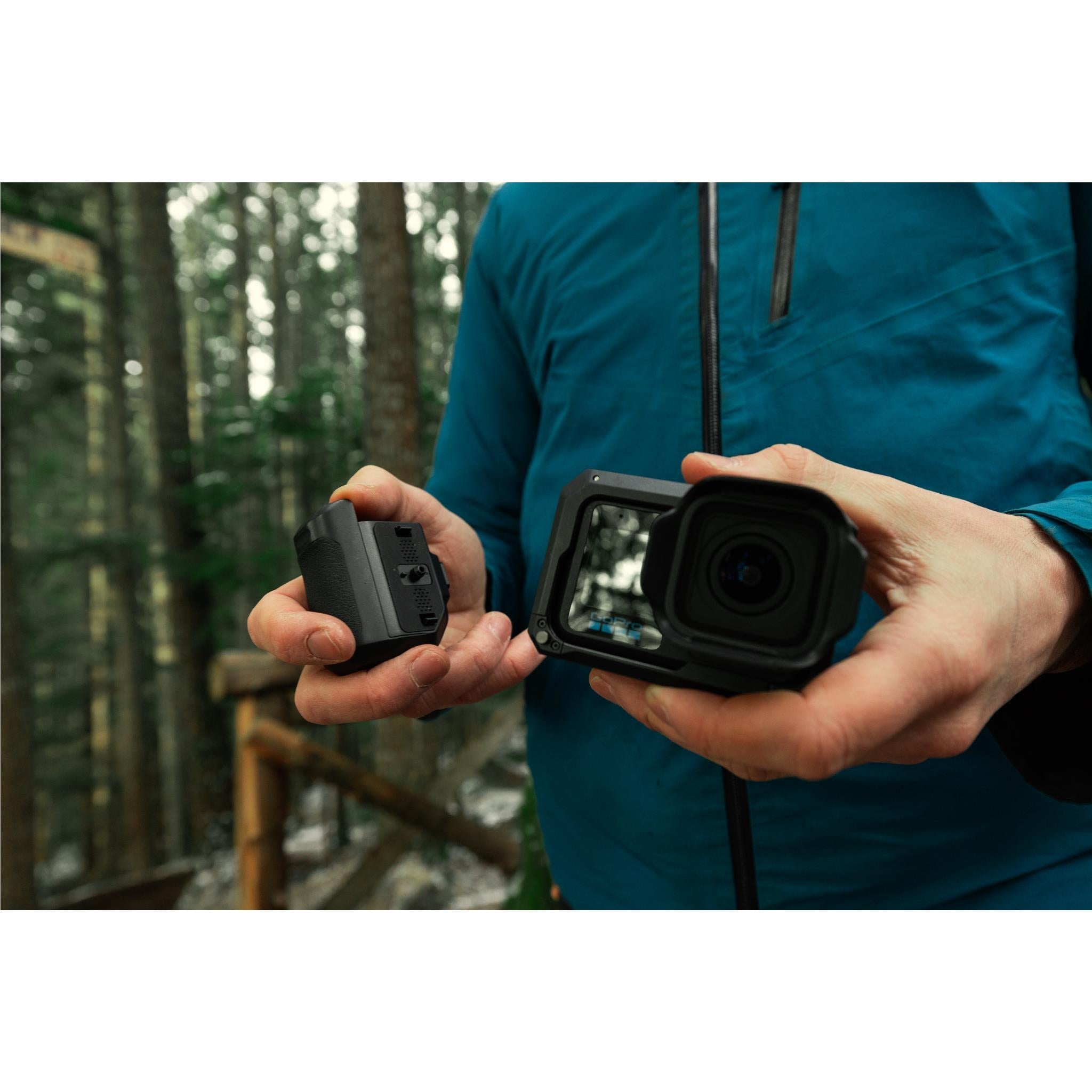 GoPro camera grip with cold shoe mount, held in hands outdoors