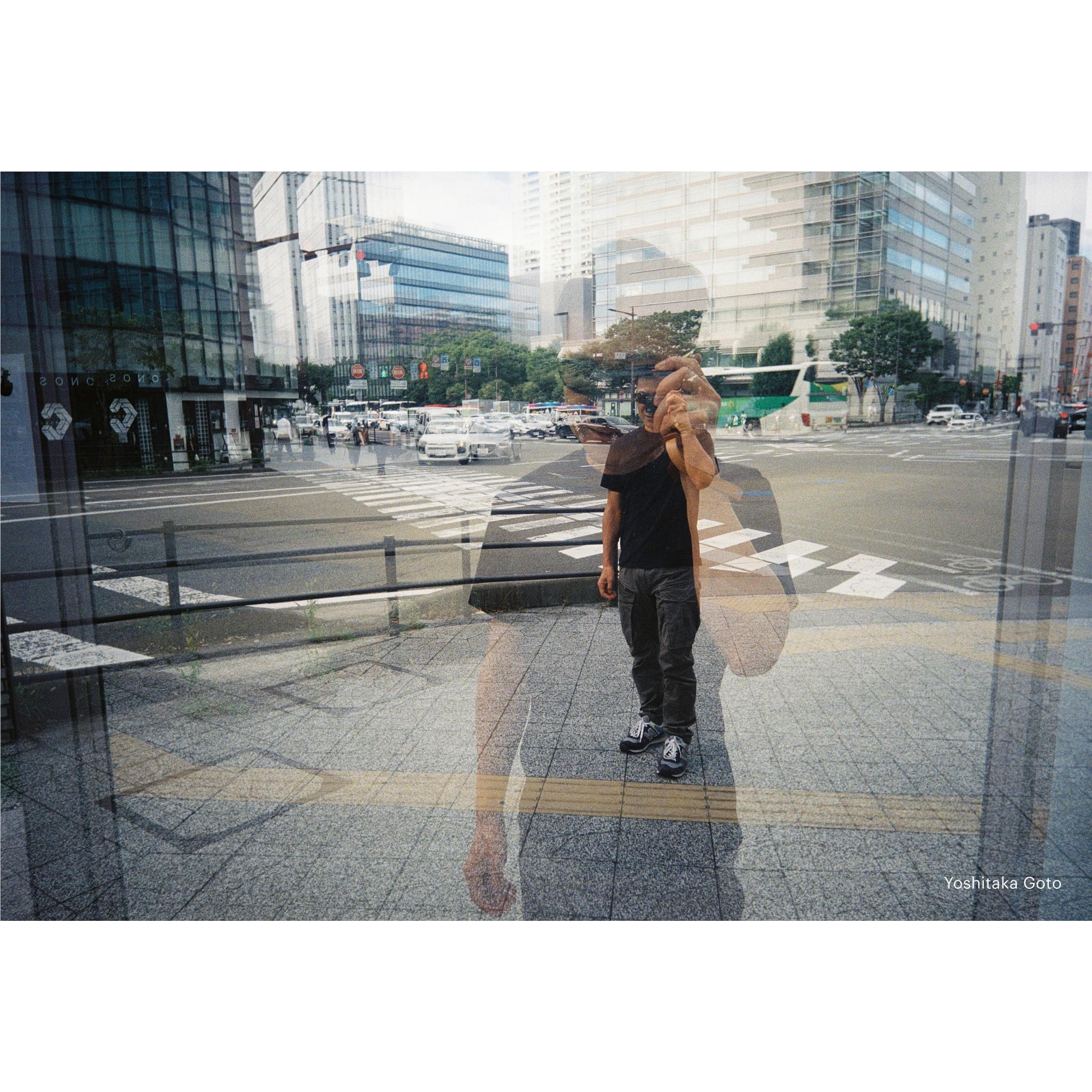 35mm film camera usage scene: person standing on a city sidewalk