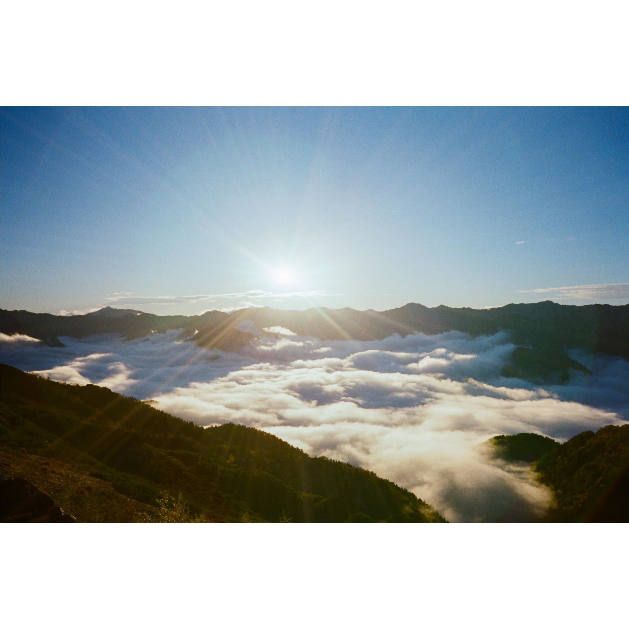 35mm film camera usage scene: mountain valley above clouds at sunrise