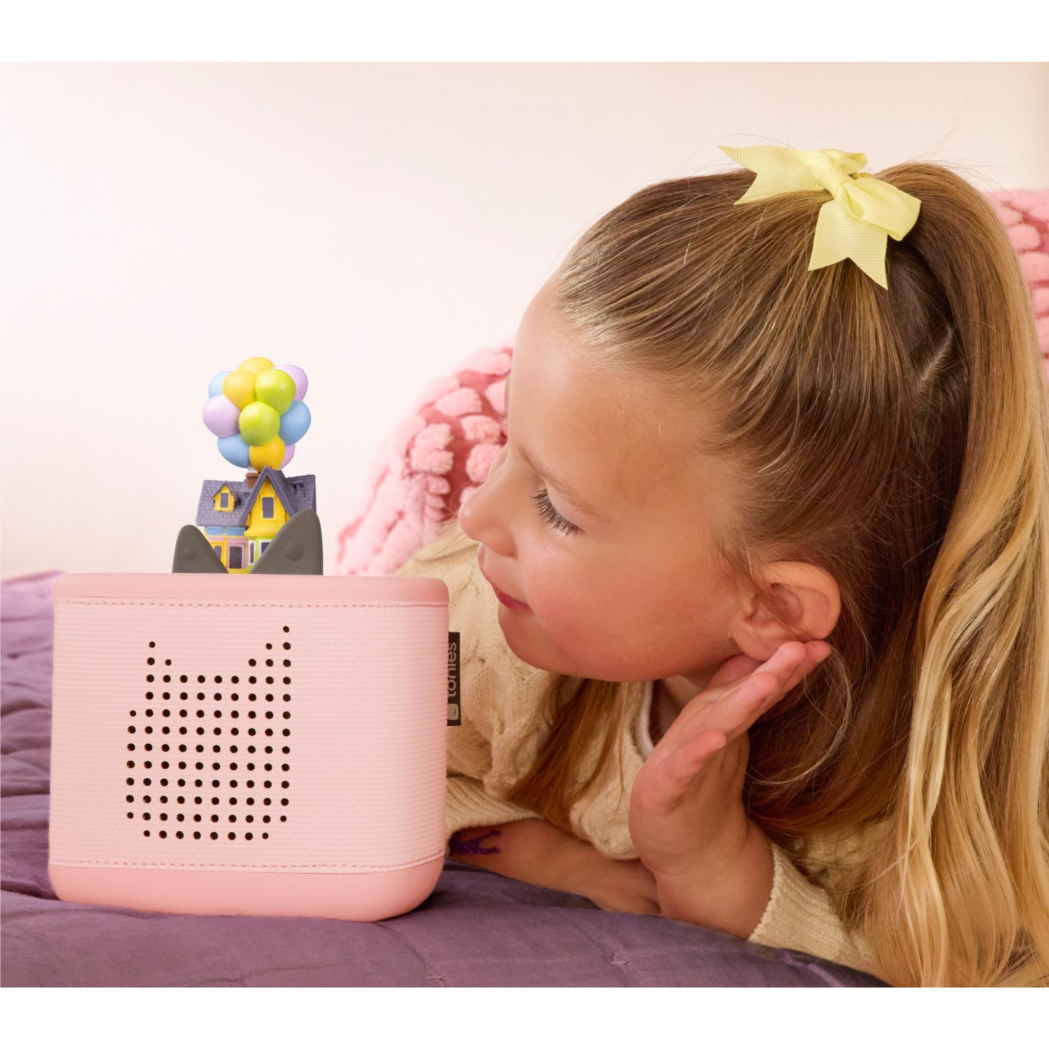 Pink Toniebox speaker with Up-themed Tonie figure on top and child listening