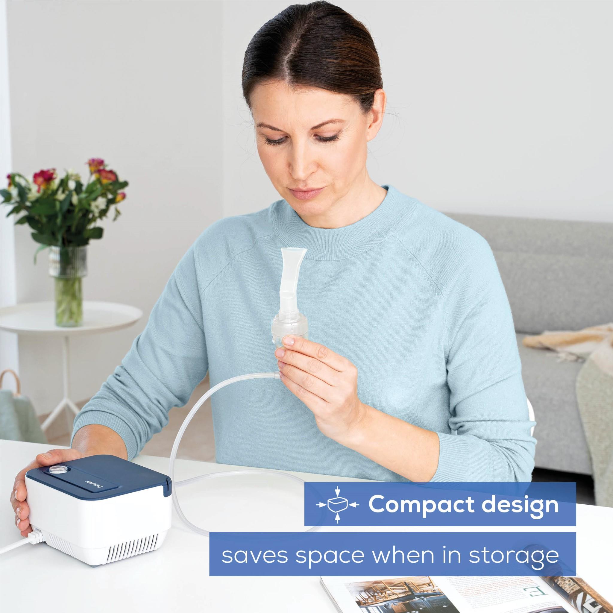 Adult holding compact compressed-air nebuliser with medication cup and tubing