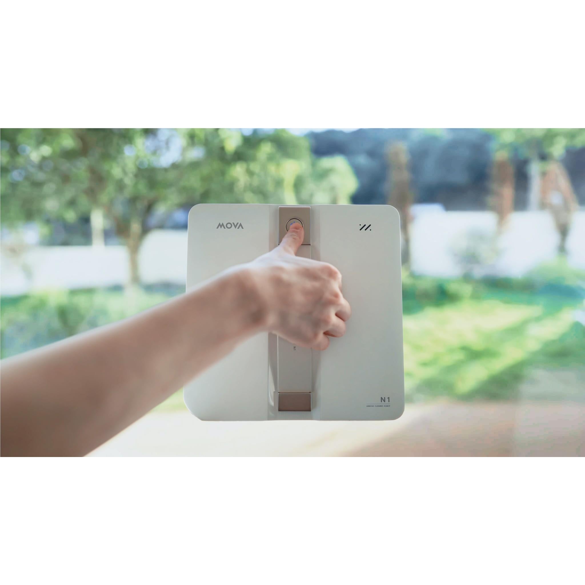 Window cleaning robot held by hand, white body with center mist panel and vents