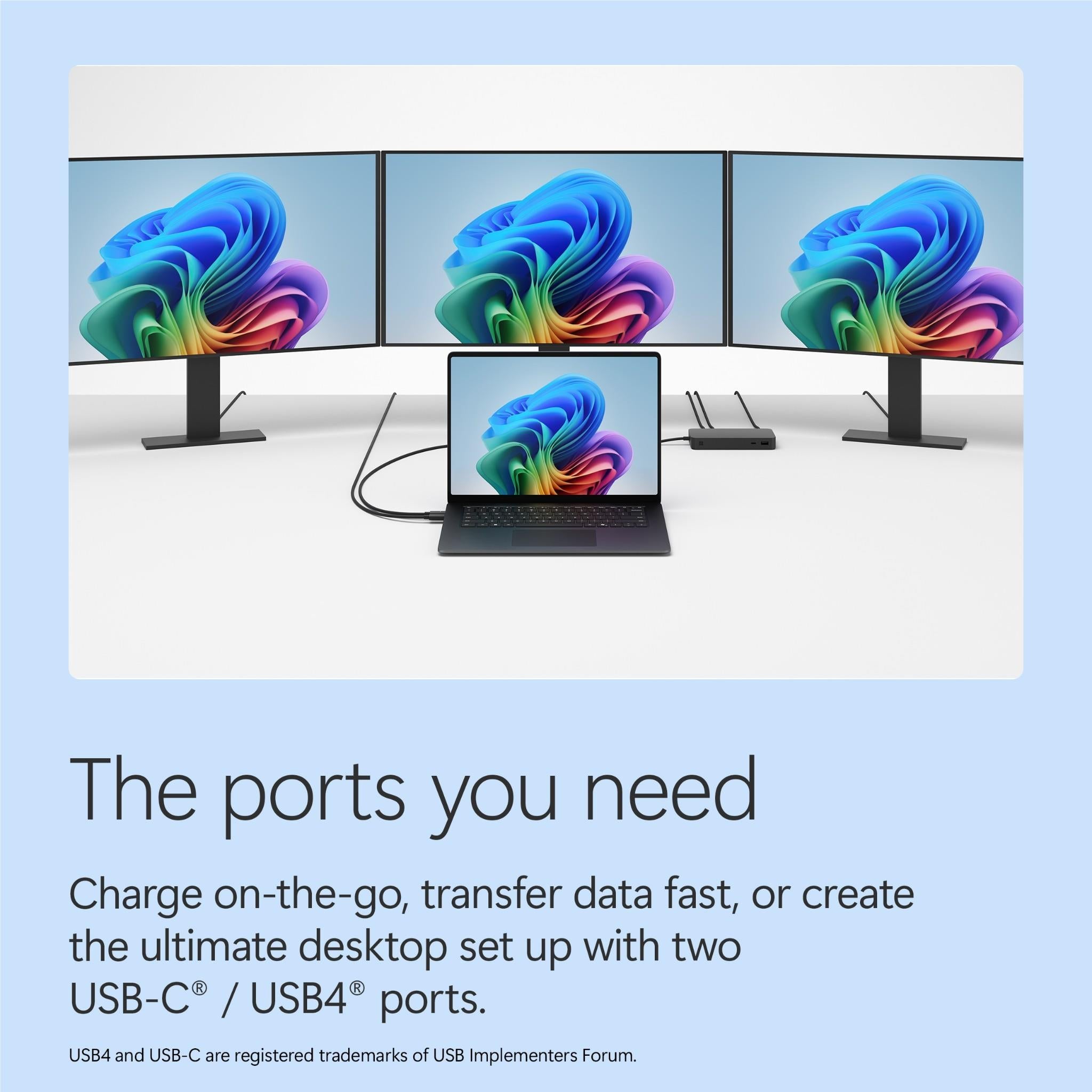 Black Surface Laptop connected to dual external monitors with cable