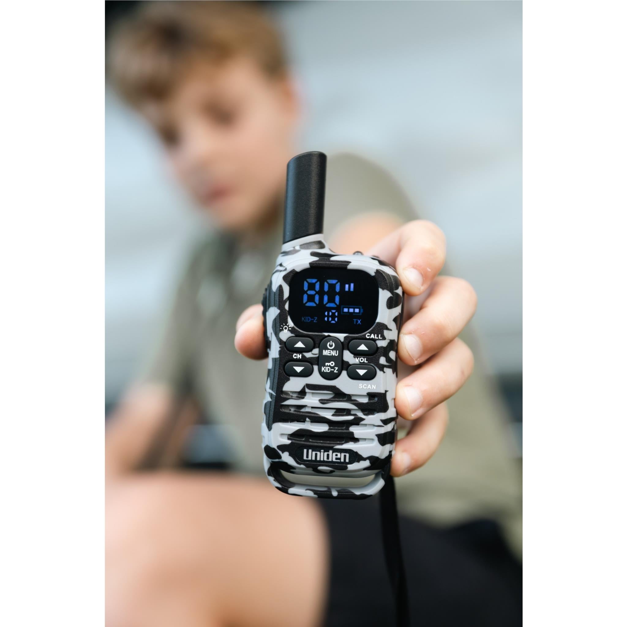 Camouflage UHF kid-zone radio in hand, front keypad and blue display