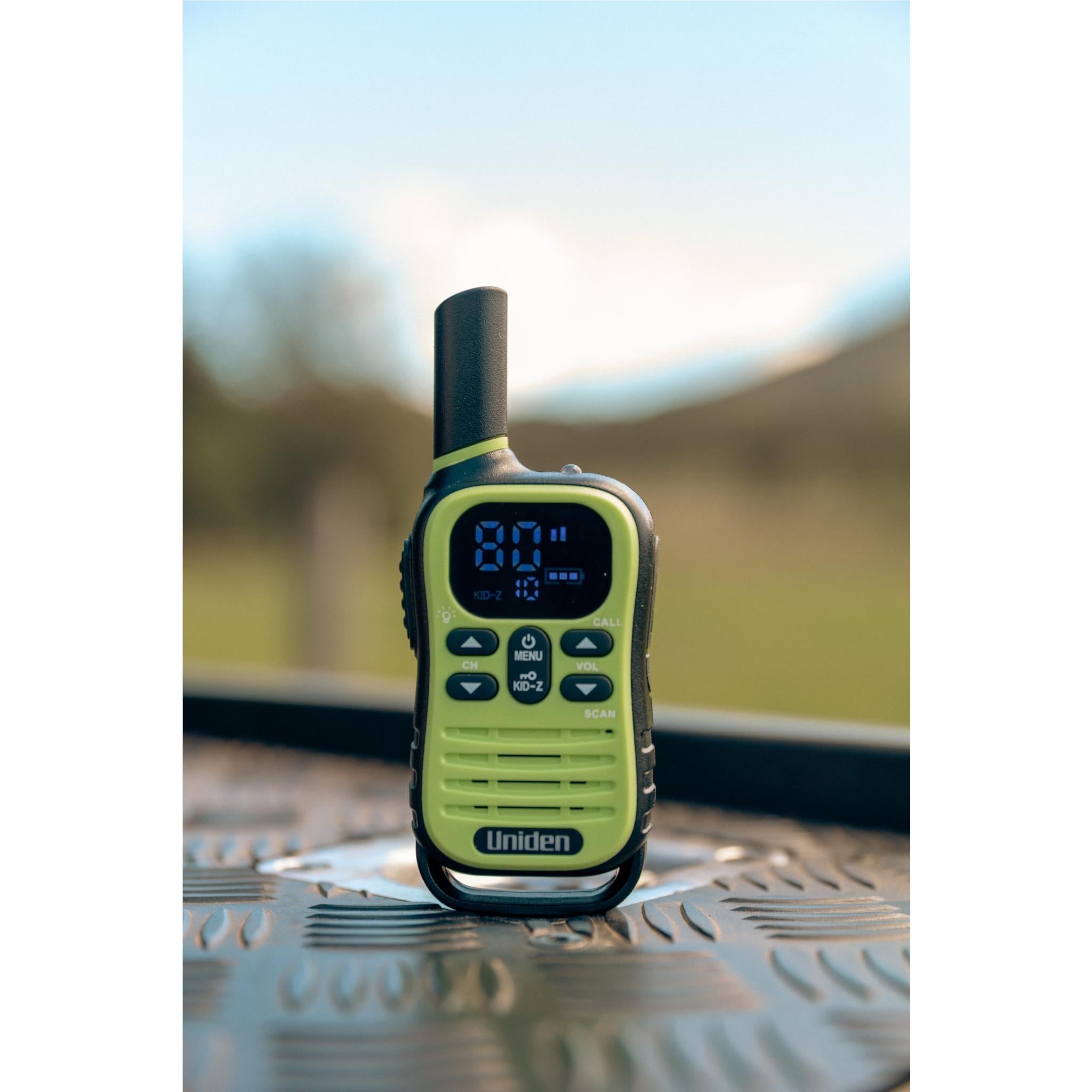 Lime green Uniden UHF kid-zone radio standing on textured metal surface