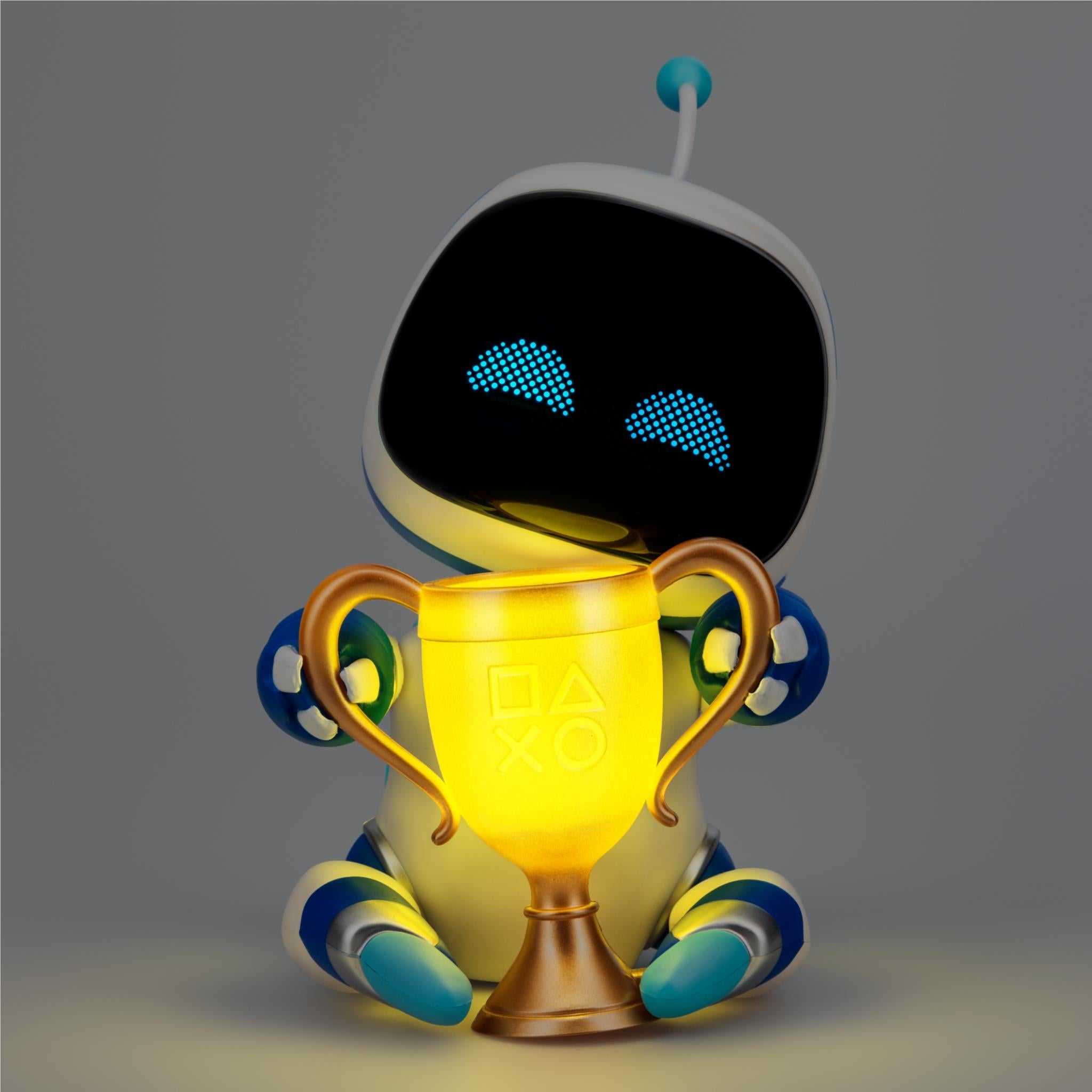 Astro Bot light figurine with gold trophy cup, blue legs, glowing blue eye dots