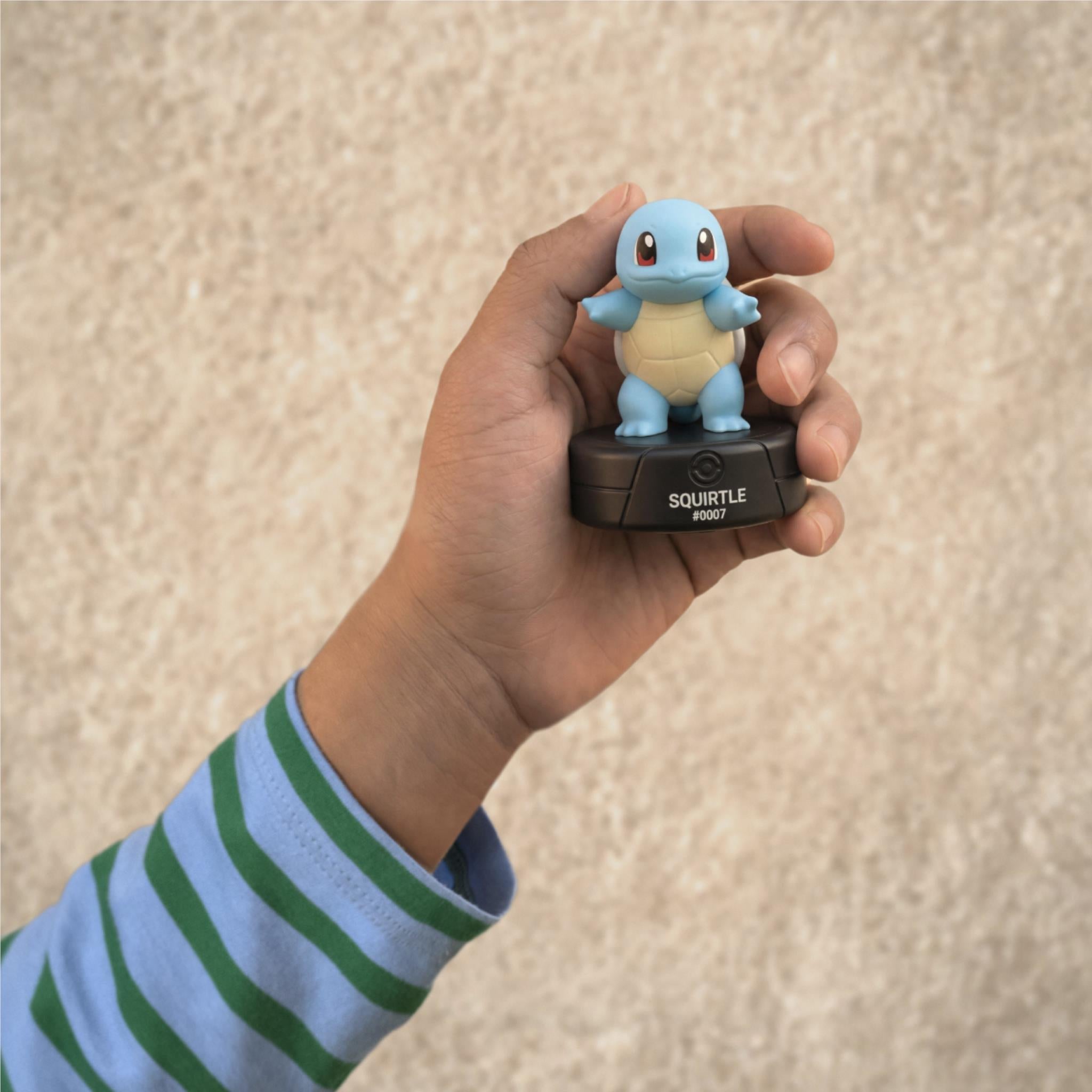 Squirtle blue audio Tonie figurine held in a hand over black base