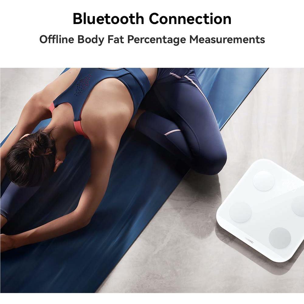 Frosty white Bluetooth body fat scale on the floor during measurements