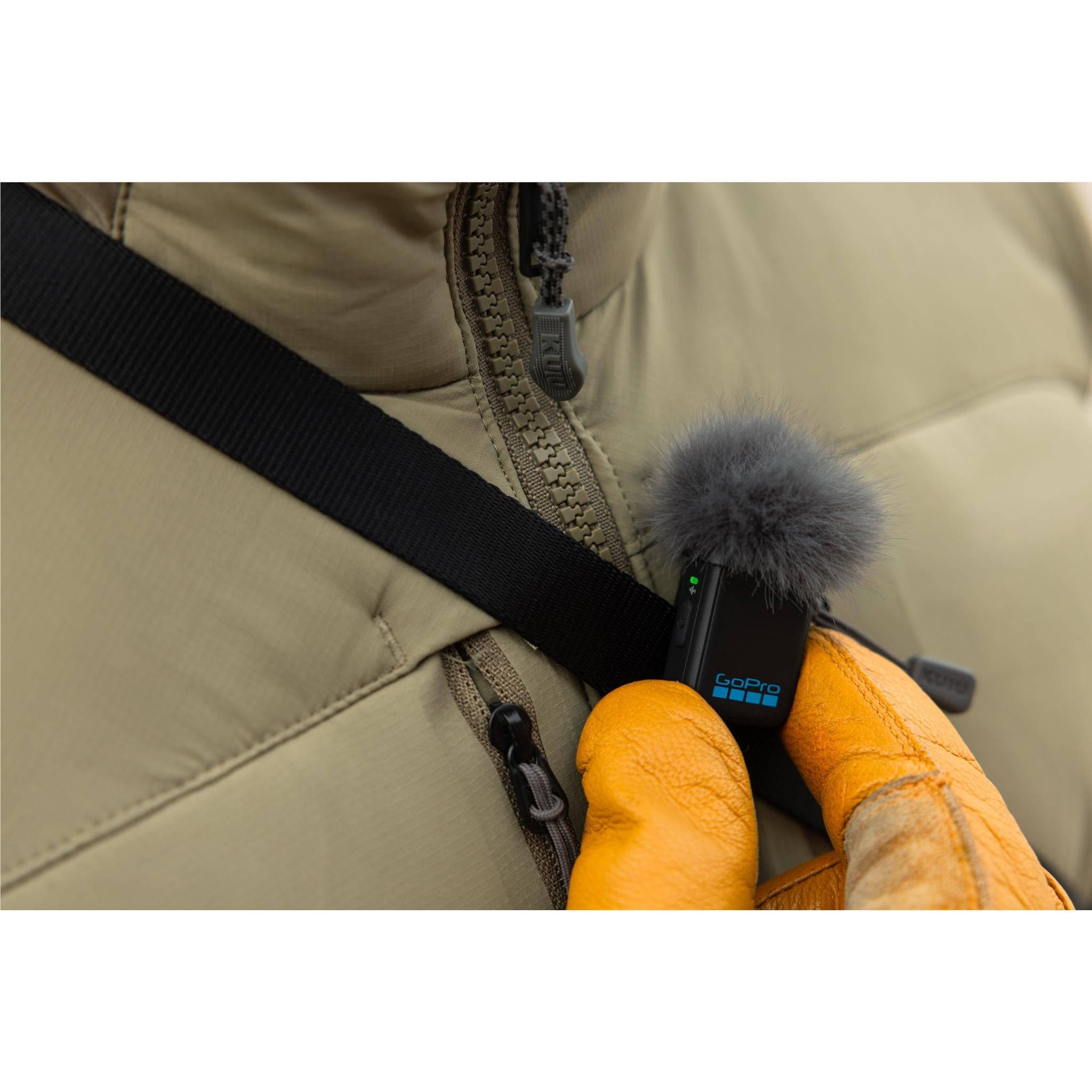 GoPro wireless microphone transmitter clipped to jacket with furry windscreen