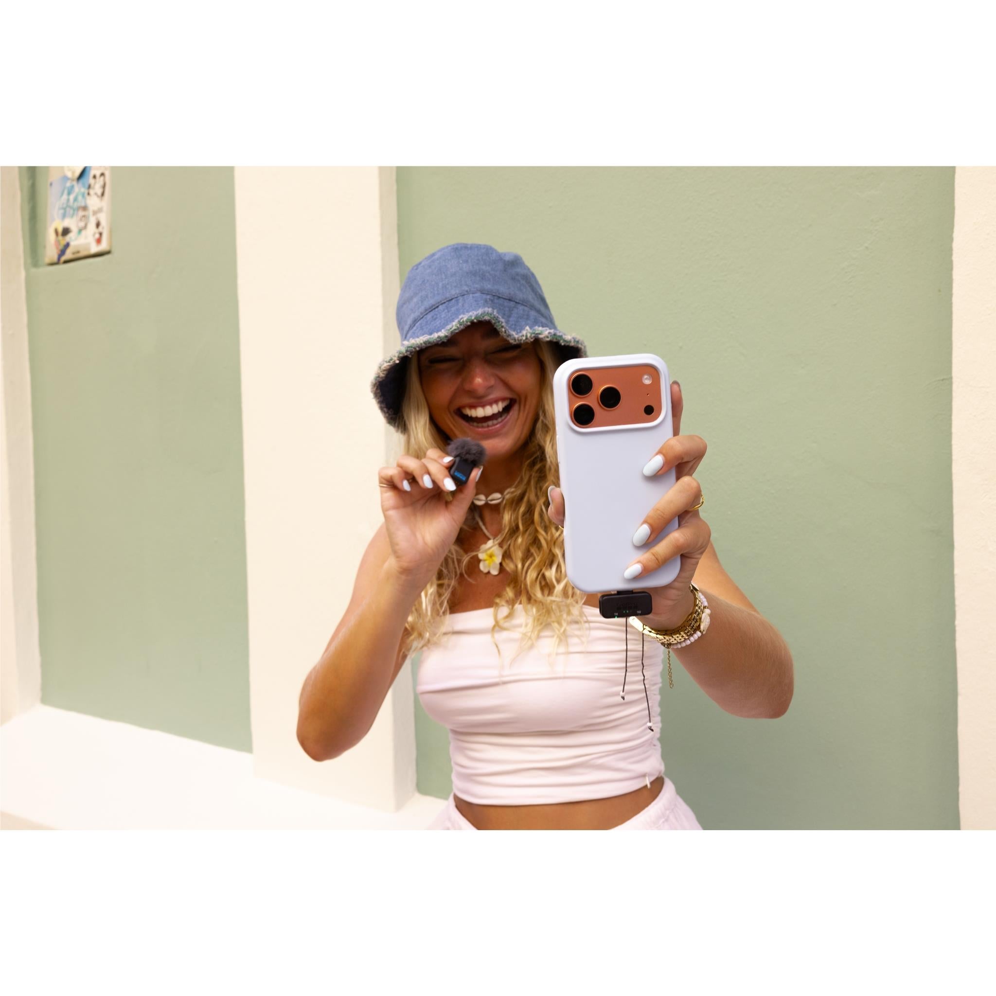 GoPro wireless microphone use: person holds mic transmitter near smartphone