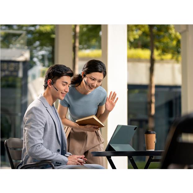 Black open-ear bone conduction headset worn by office worker with mic boom