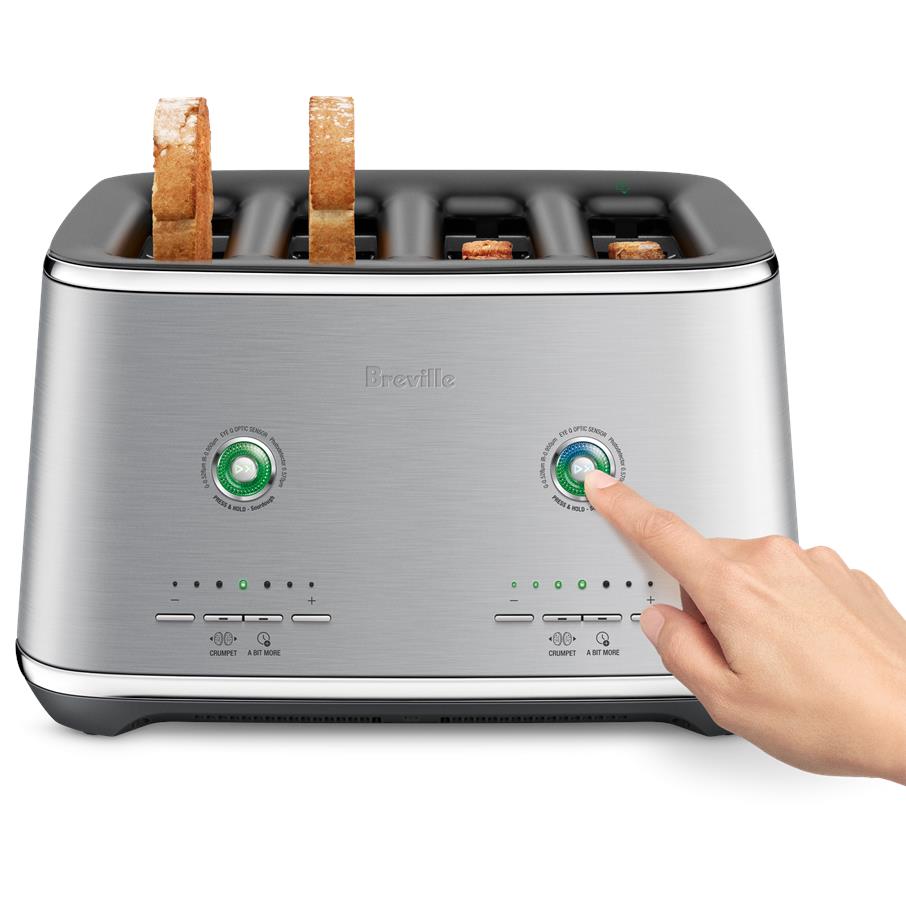 Brushed stainless 4-slice toaster with bread in slots and hand turning a green dial