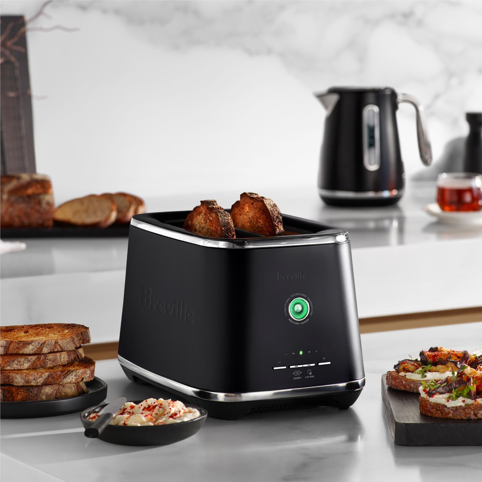 Black countertop toaster with two toasting slots and bread inside