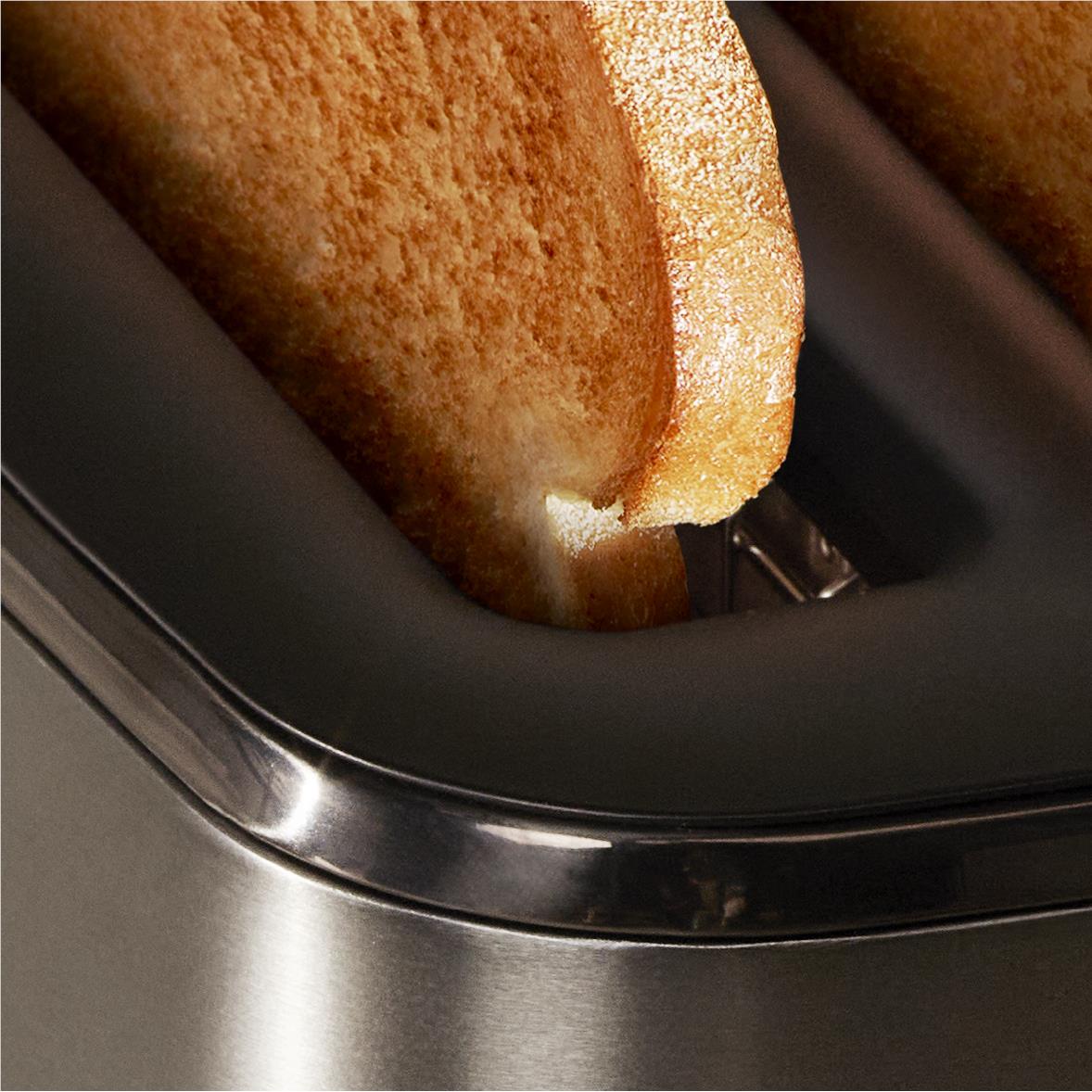 Close-up of bread toasting inside a black two-slice toaster slot