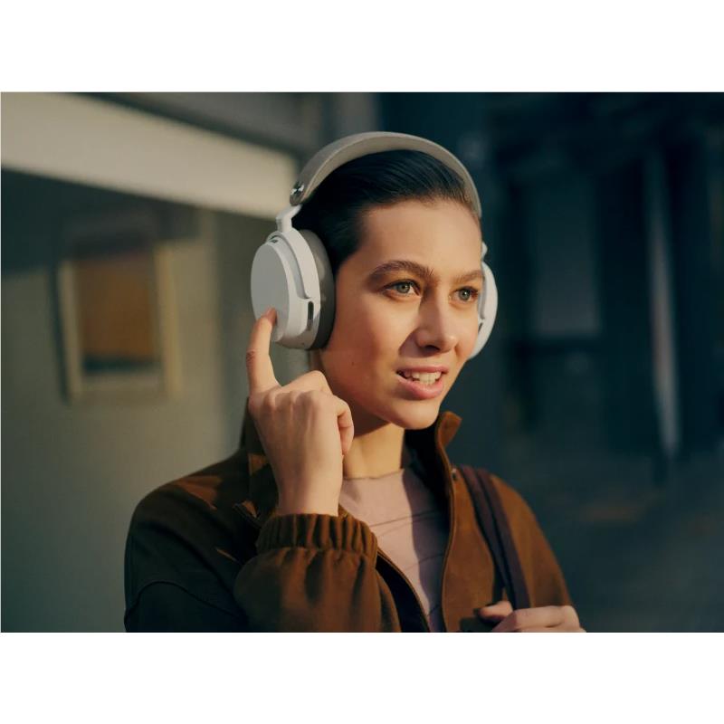 Over-ear headphones on a person’s head, white earcups and gray headband