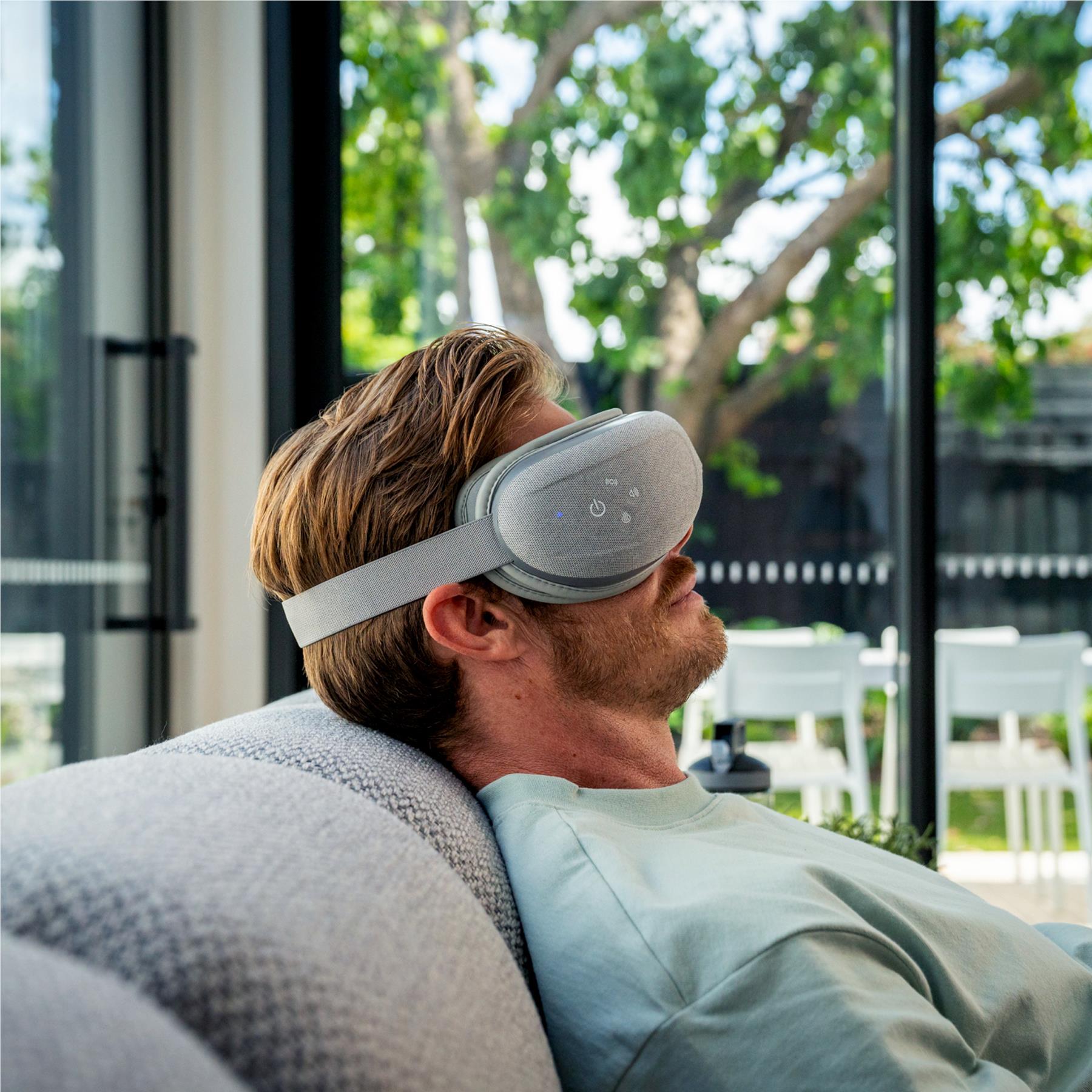 Grey hot and cold eye massager with gel mask, worn over eyes