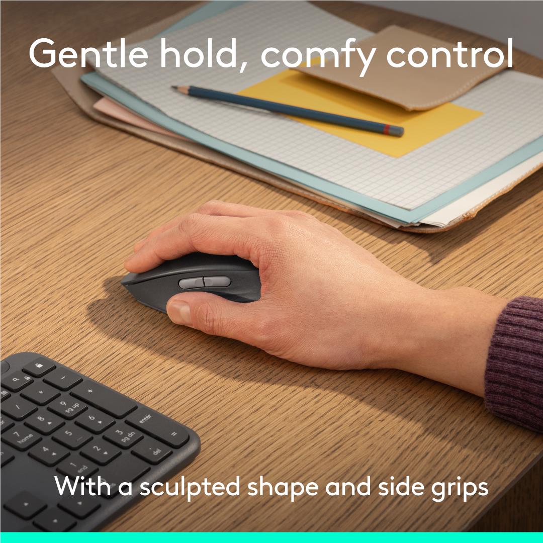Hand holding Logitech graphite quiet-click mouse on a desktop surface